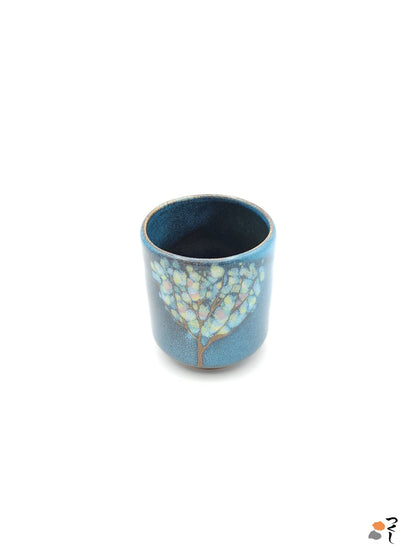 Authentic Japanese pottery teacup tall with tree pattern decoration. blue color. (side view 1).