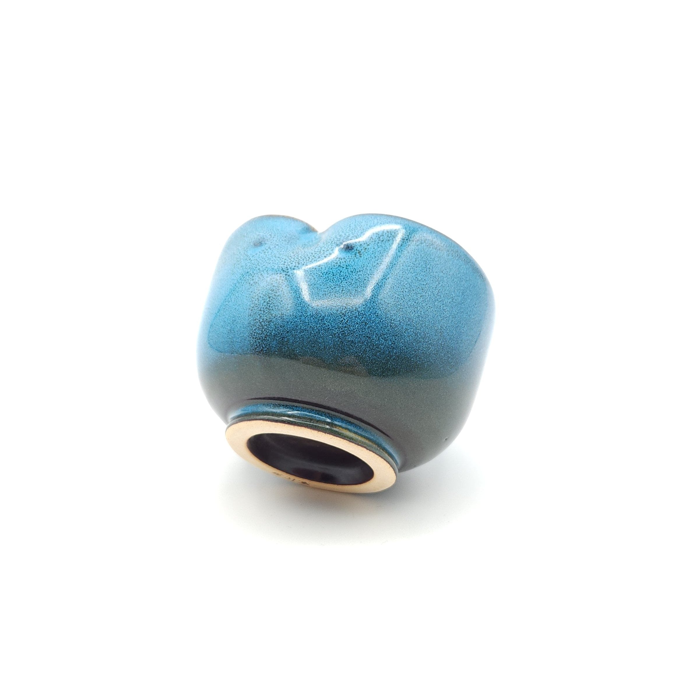 Back side view of a Japanese blue Teacup made of pottery with an Owl motif.
