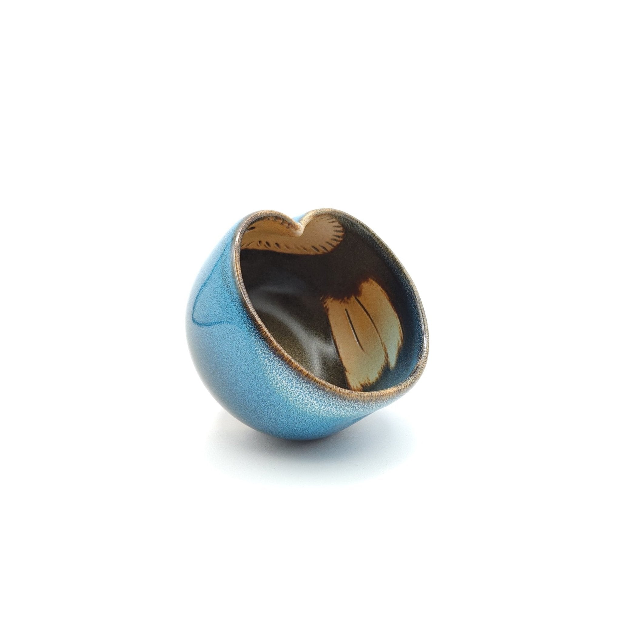 Oblique view of a Japanese blue Teacup made of pottery with an Owl motif.
