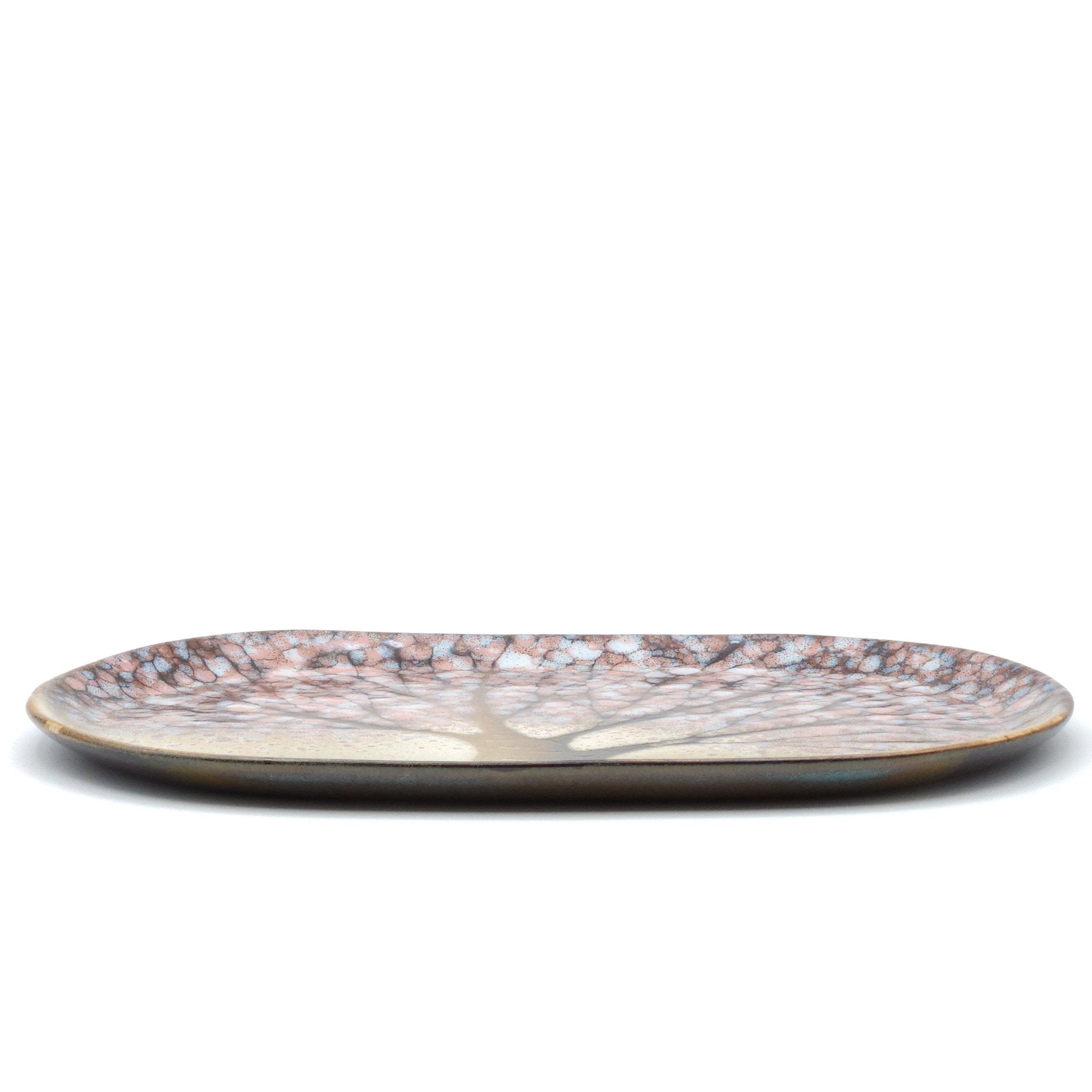 A Japanese plate made of pottery with cherry blossoms motif in green background. Long side view