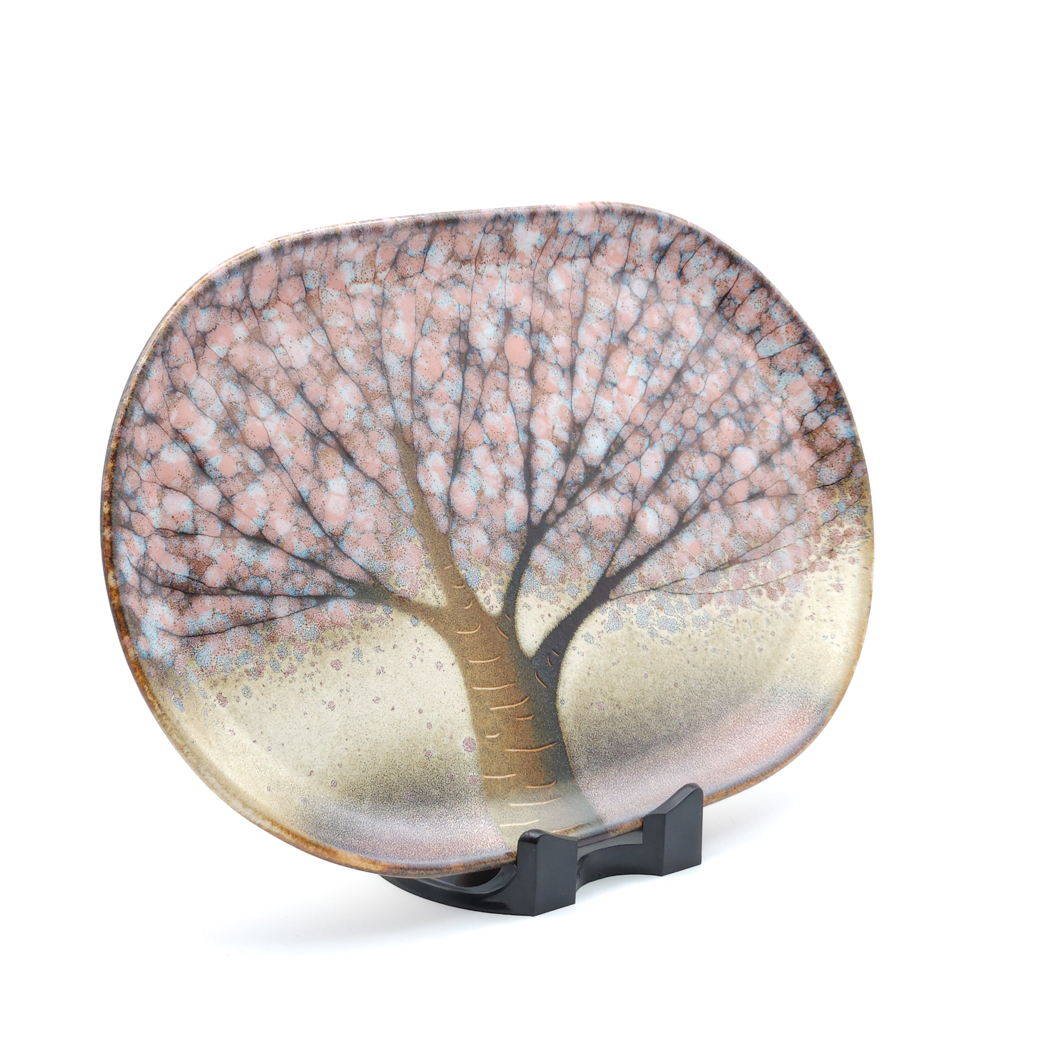 A Japanese plate made of pottery with cherry blossoms motif in pink background. Lateral view