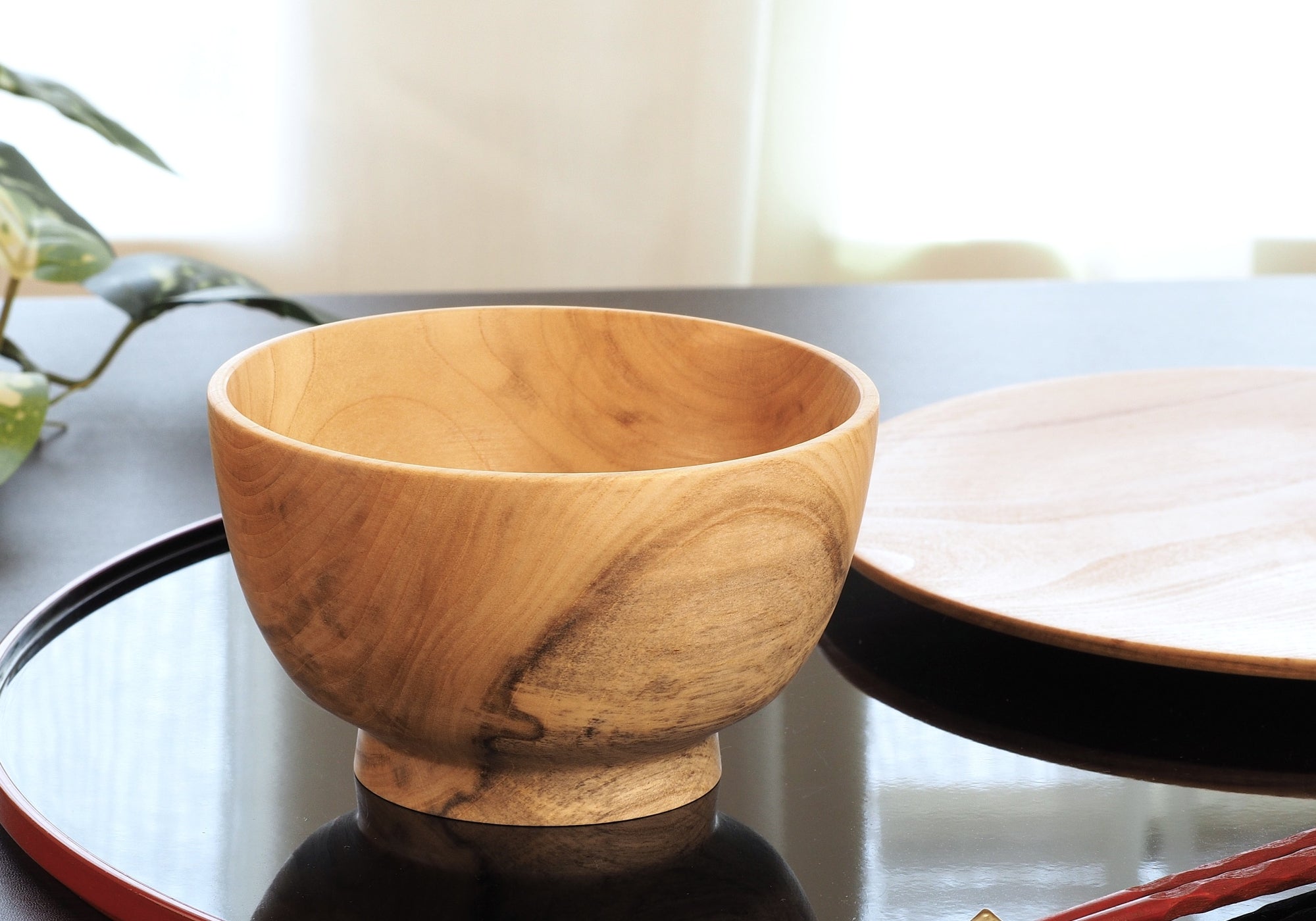 Japanese elm handcrafted wooden bowl on lifestyle background. Tsukushi