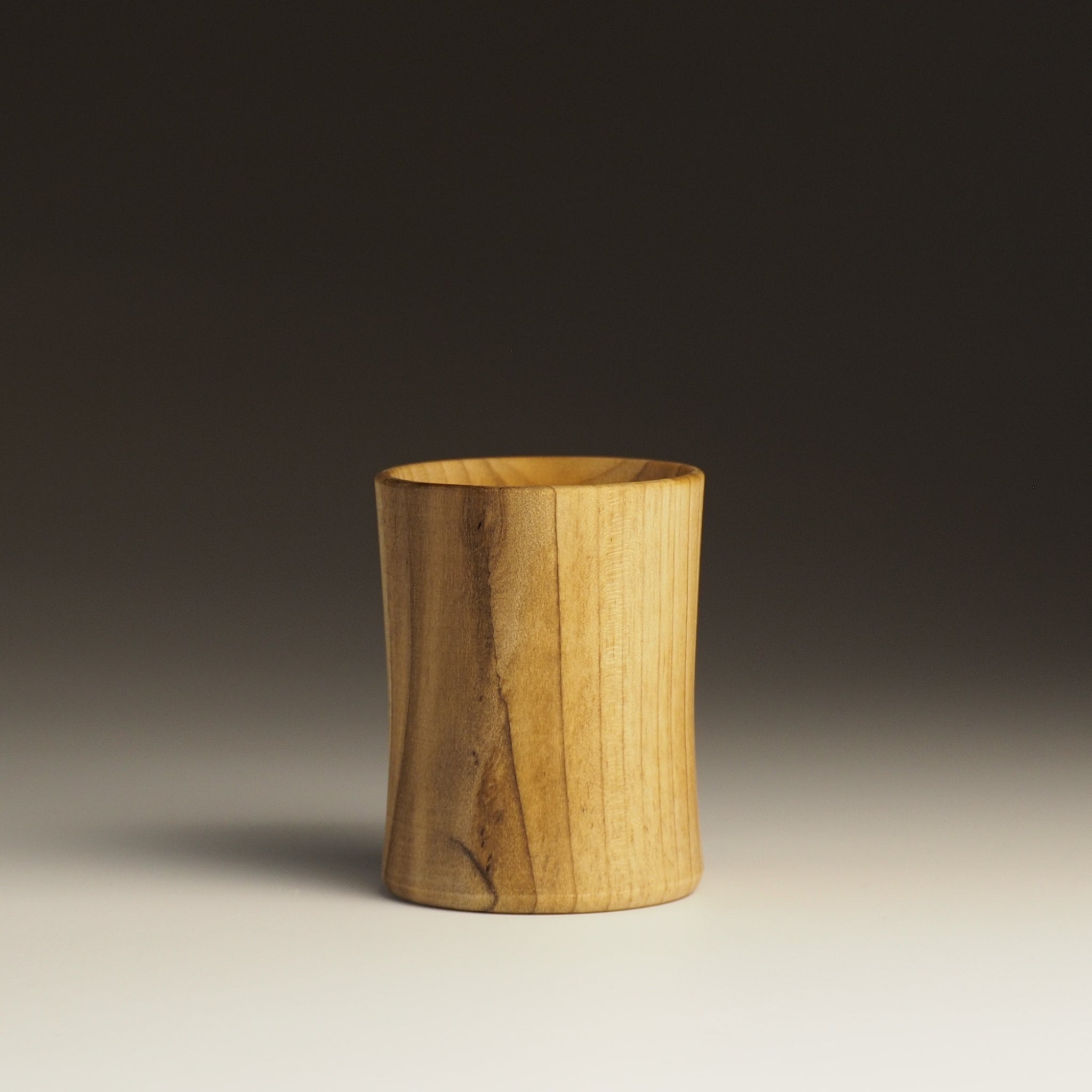 Japanese handcrafted wooden sake cup black to white background. Tsukushi
