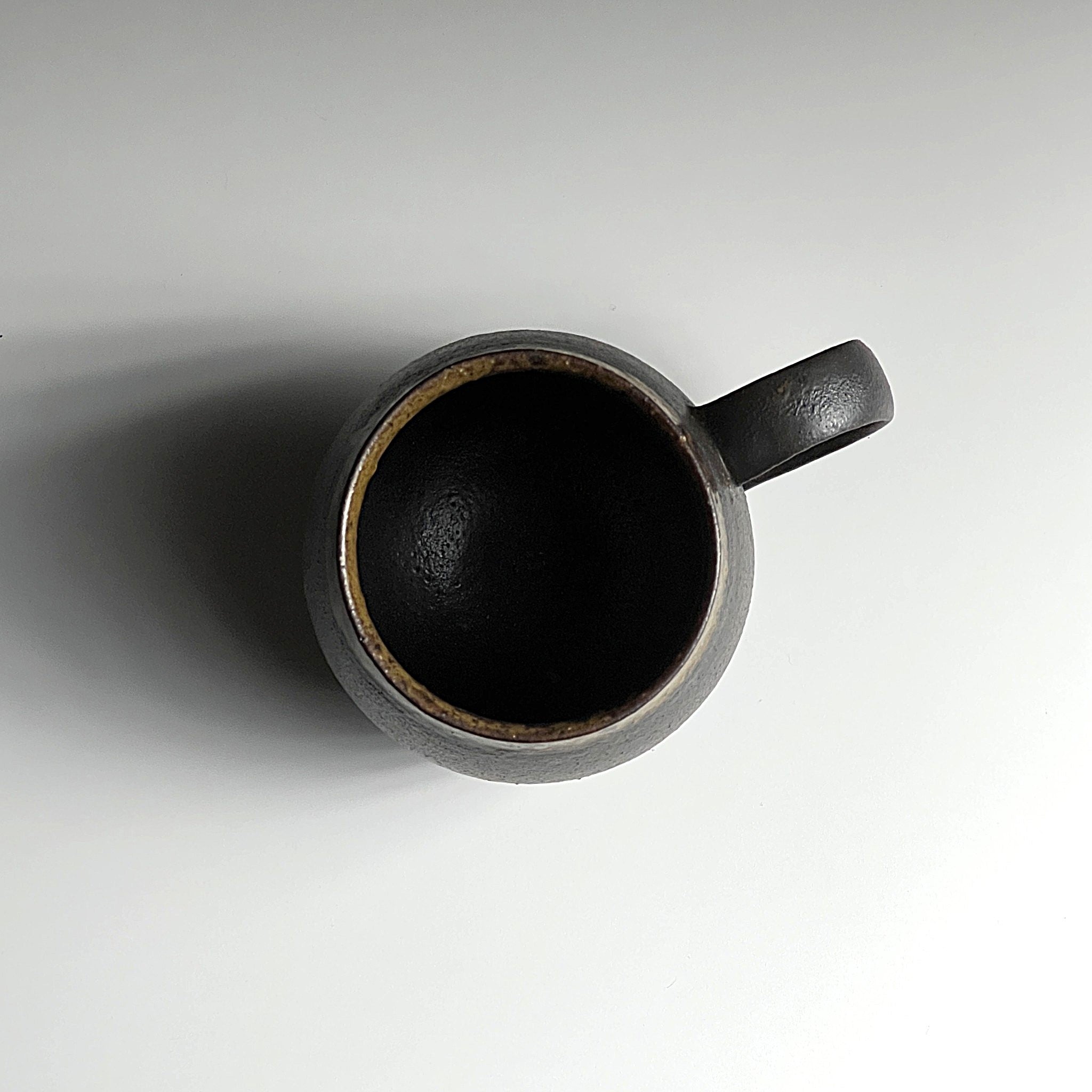 Top view of black Japanese ceramic tea mug on a white background, Tsukushi