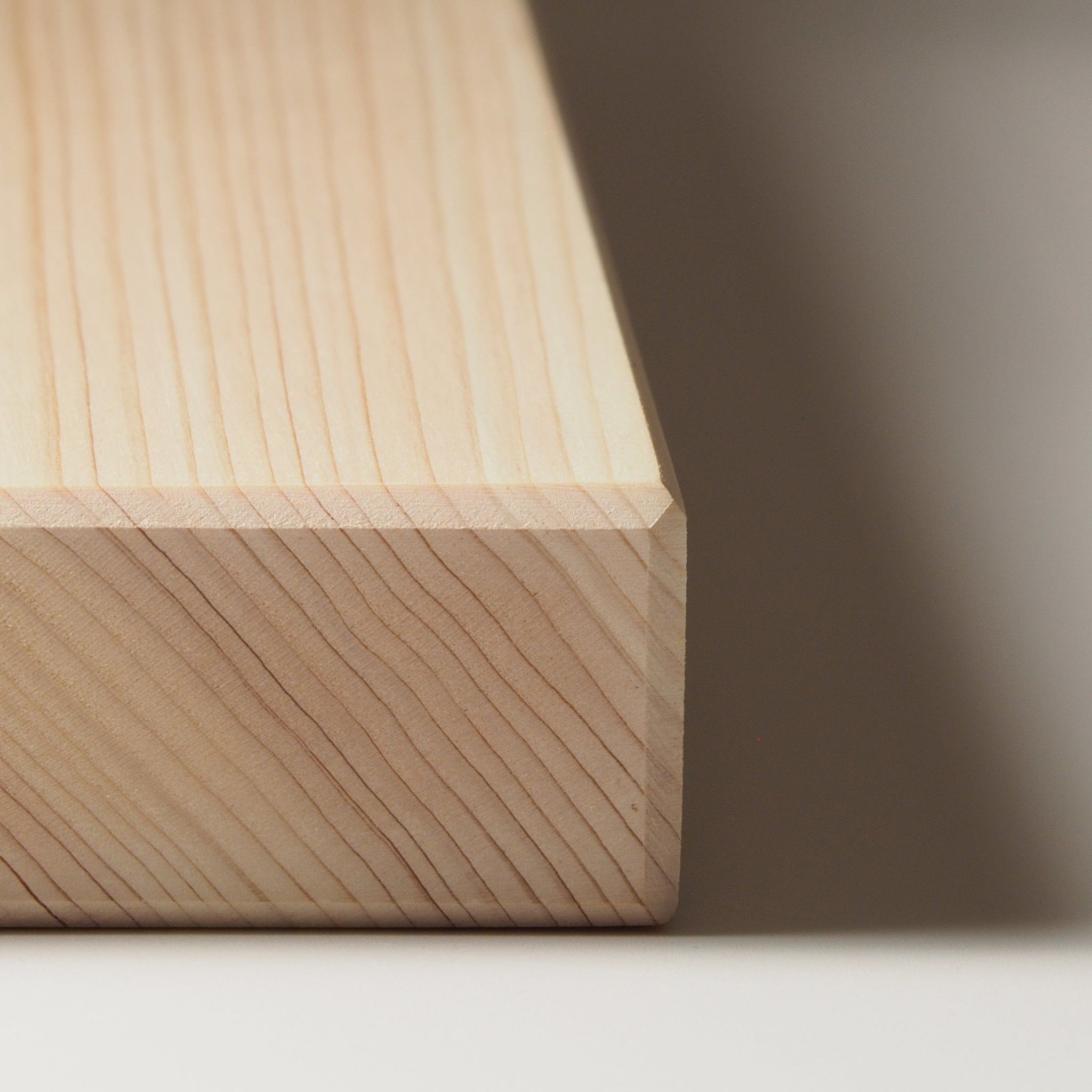 Close-up of a Japanese wooden cutting board on a neutral background. Tsukushi