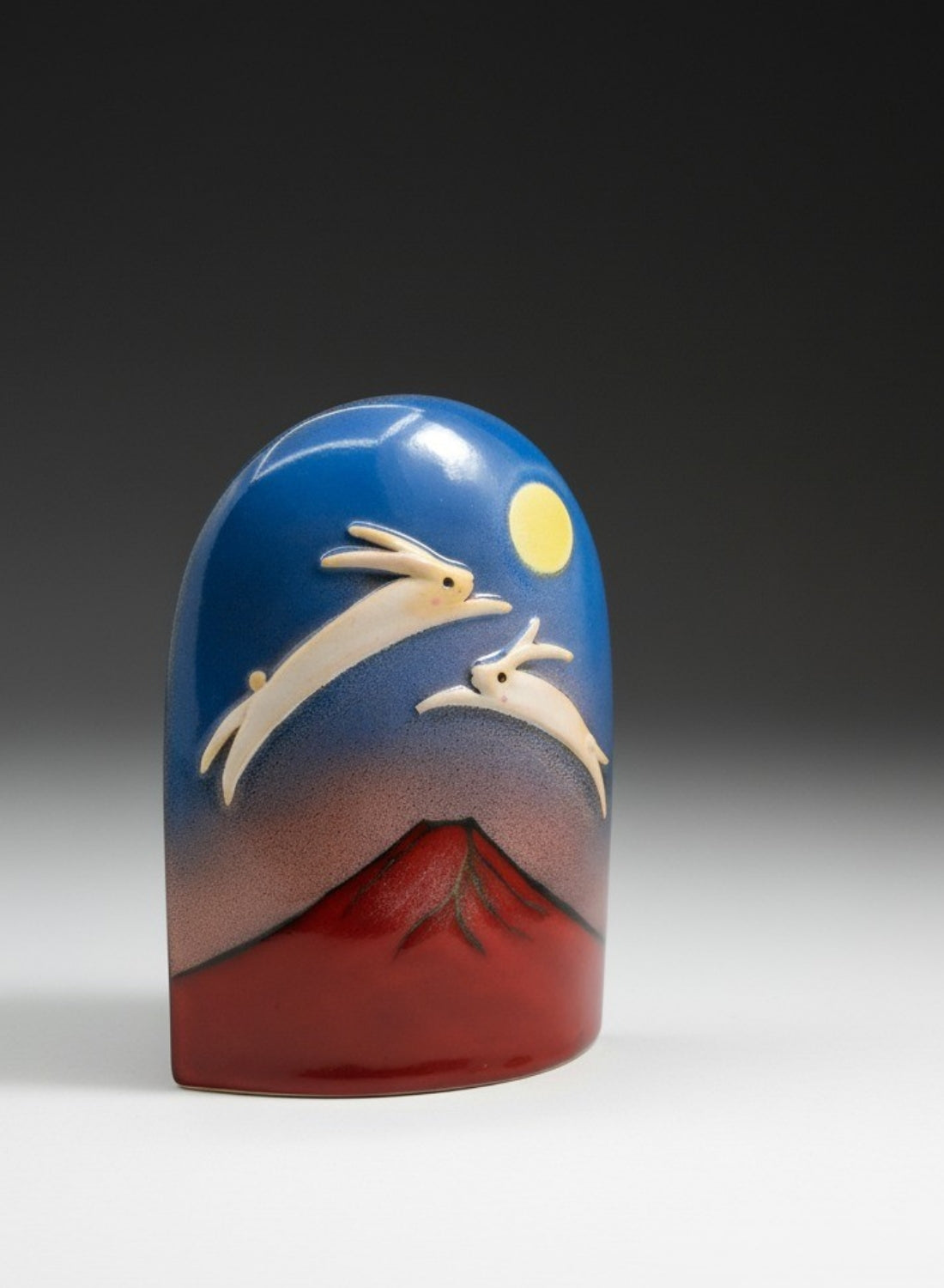 A decorative object design featuring Mount Fuji, two jumping rabbits, and a full moon against a gradient background. Tsukushi