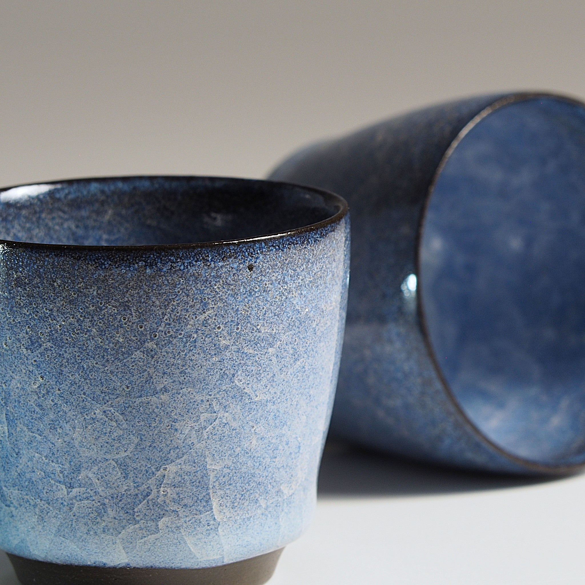 Japanese handcrafted crazing ceramic Sake cups beige background, Tsukushi