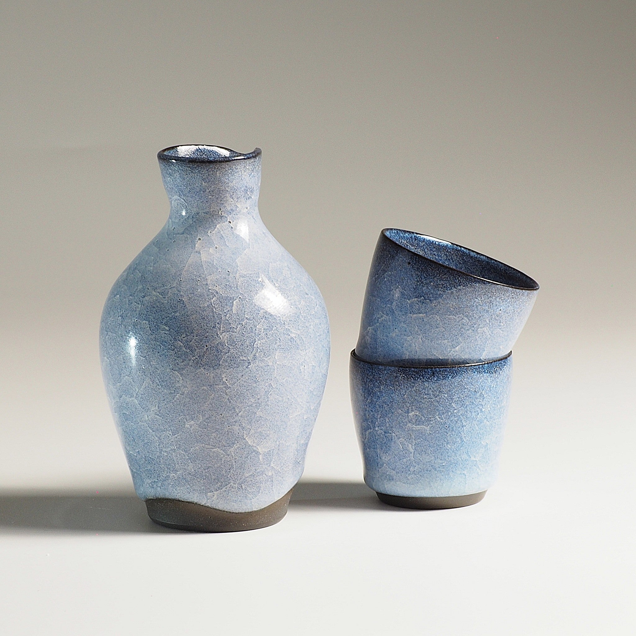 Japanese handcrafted crazing ceramic Sake set beige gradation background with shadow, Tsukushi