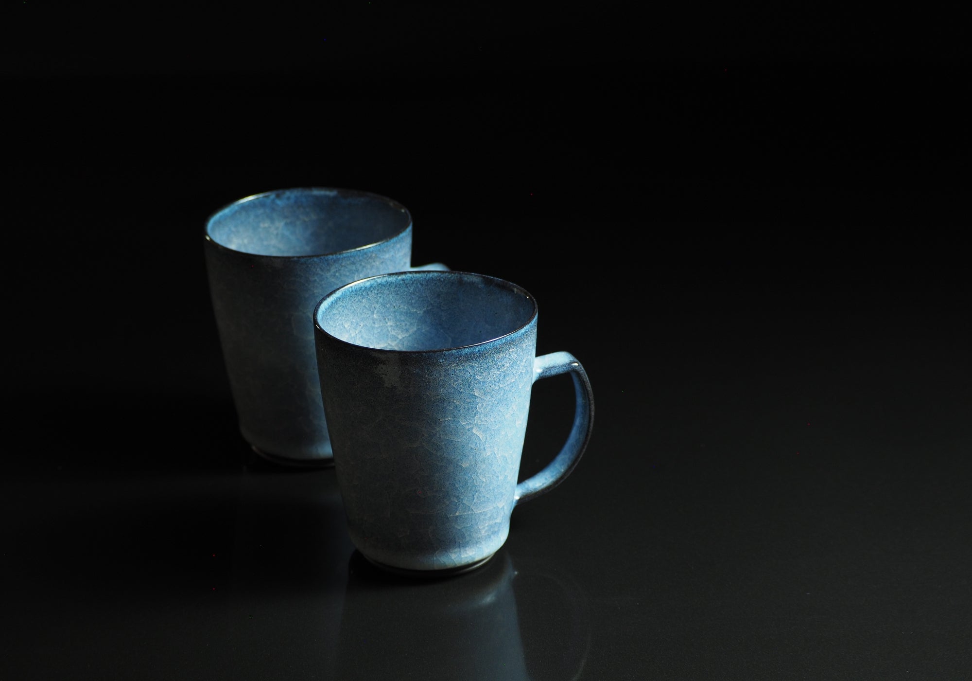 Japanese handcrafted crazing ceramic Tea mugs black background reflection from side, Tsukushi