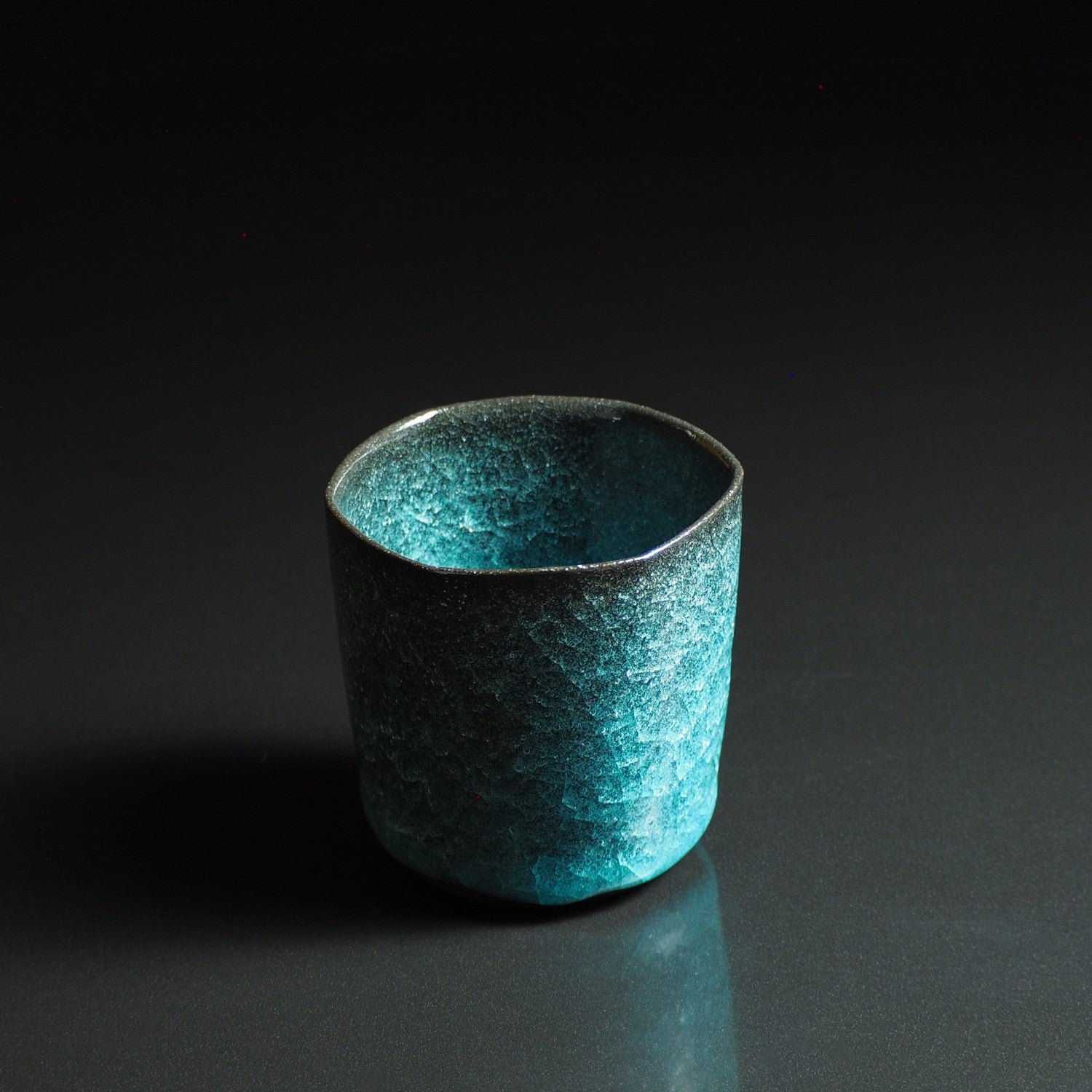 Japanese handcrafted crazing ceramic Teacup black background reflection, Tsukushi