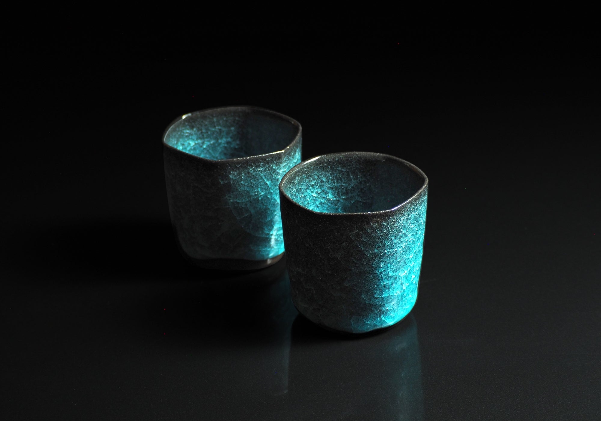 Japanese handcrafted crazing ceramic Teacups background black, Tsukushi