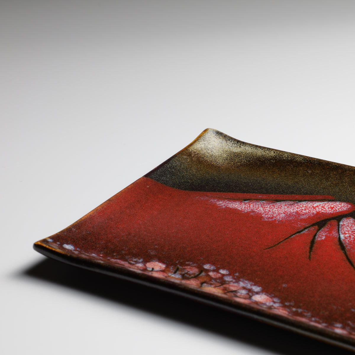 Detail of Akafuji Japanese plate showing the red Mount Fuji landscape and glazed edge