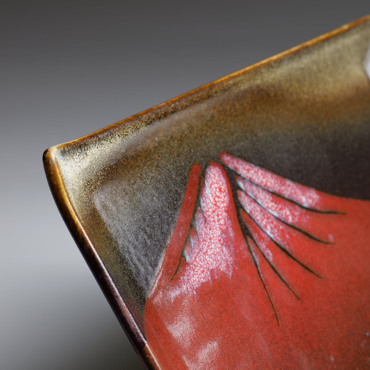 Close-up of Akafuji plate showing the red Mount Fuji motif and dark glazed surface