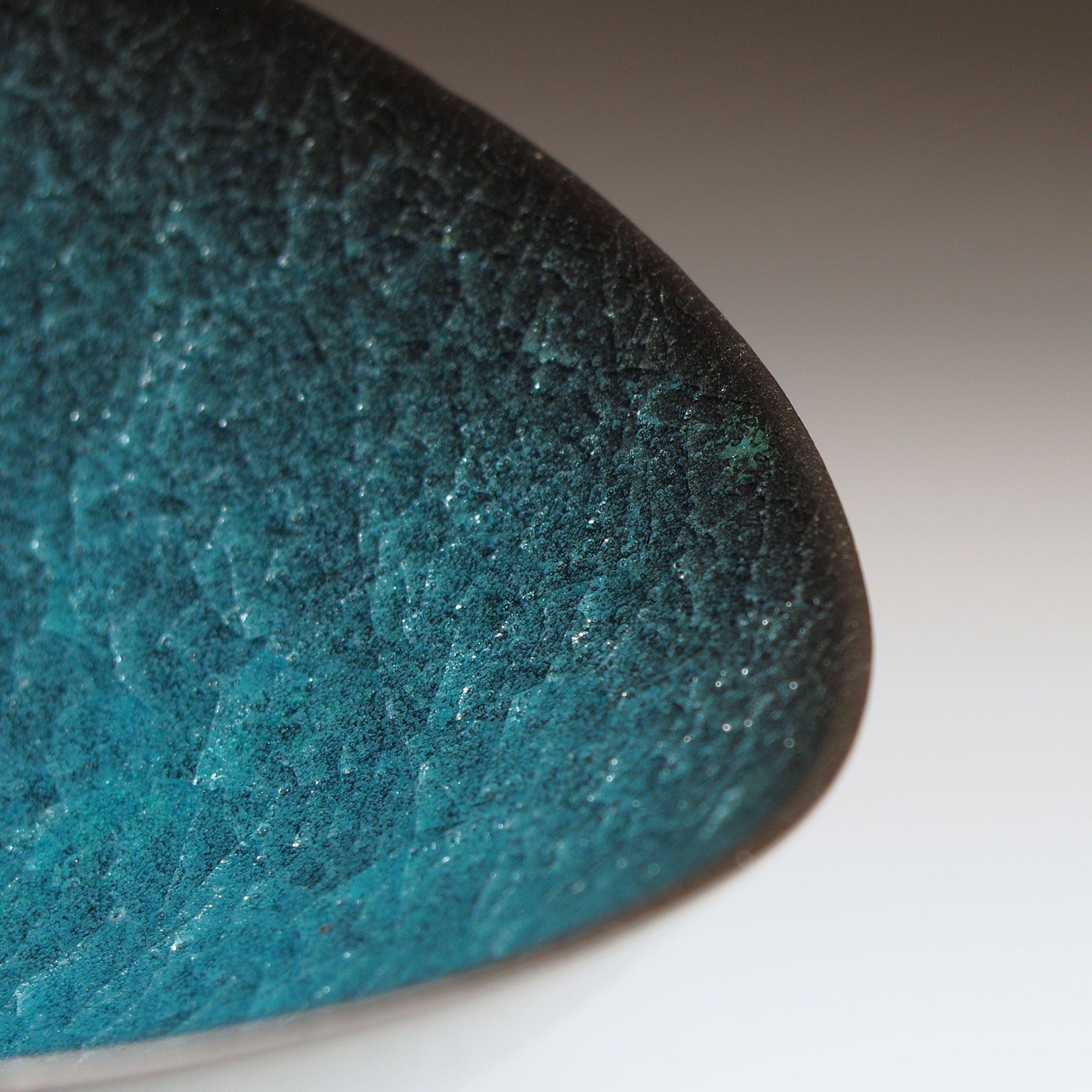 Aonami waved serving bowl, close-up of outer rim showing kannyu craquelé texture in deep teal and jade. Usurai Pottery, Japan.