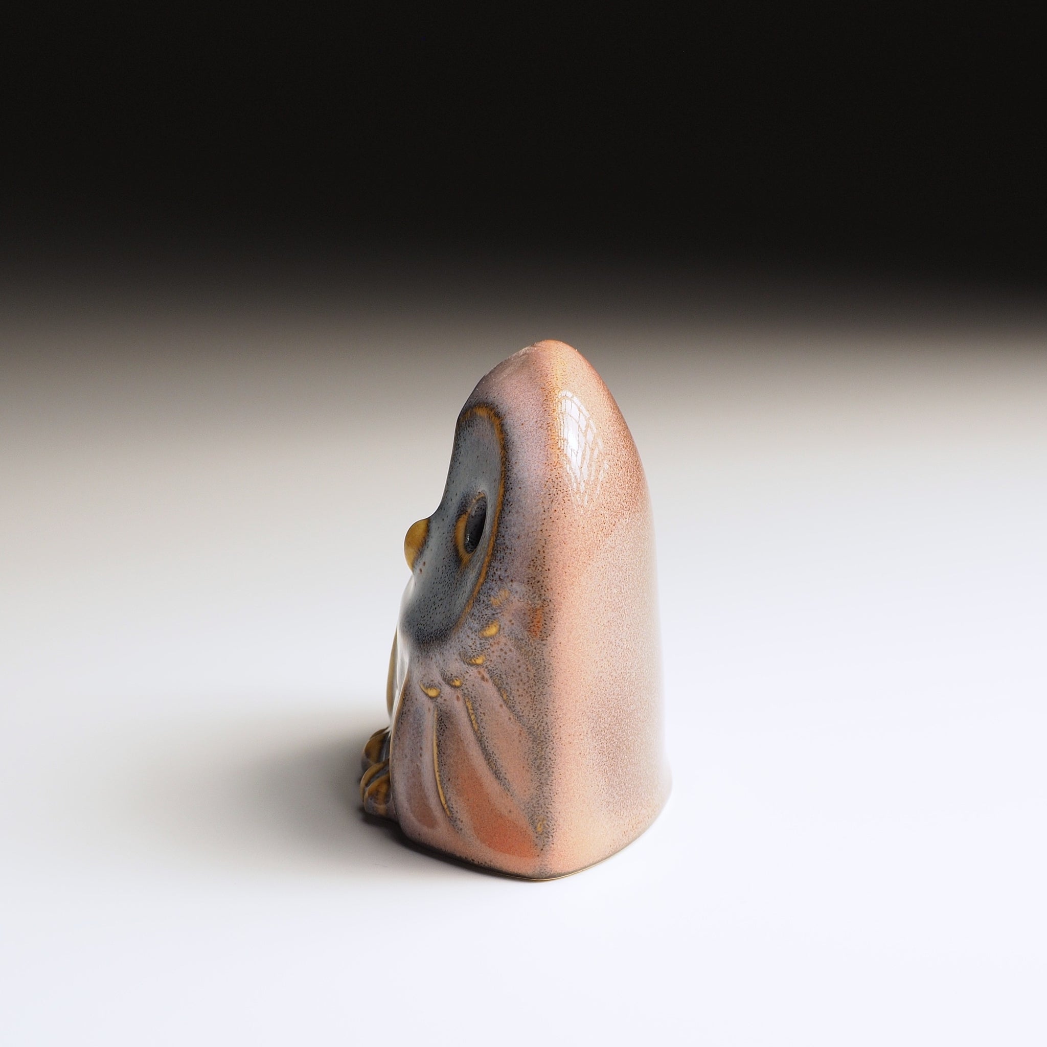 Engifuku owl figurine by Kazuhiro Kojima seen from the left side, pink and grey speckled glaze, golden details, hollow eyes.
