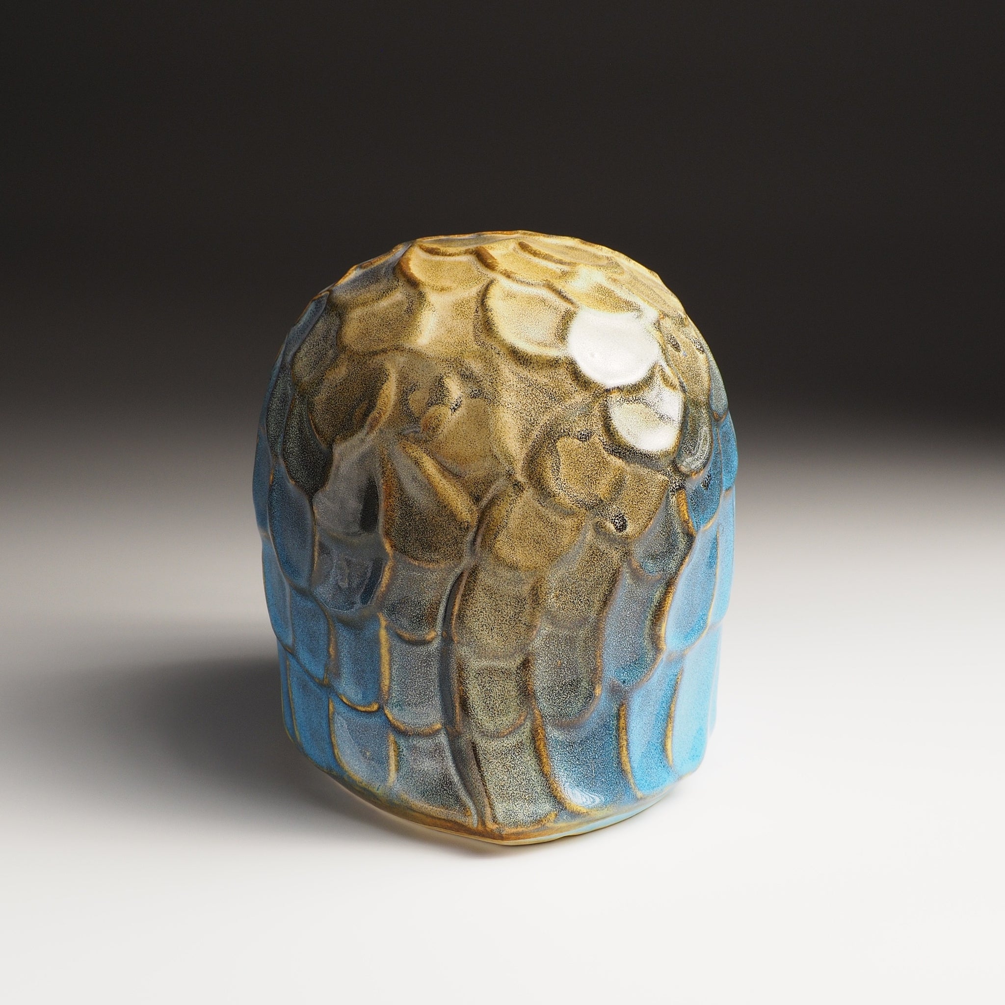 Large Fukumori owl figurine, back view, rounded dome of overlapping feather scales in cerulean blue and warm amber glaze.