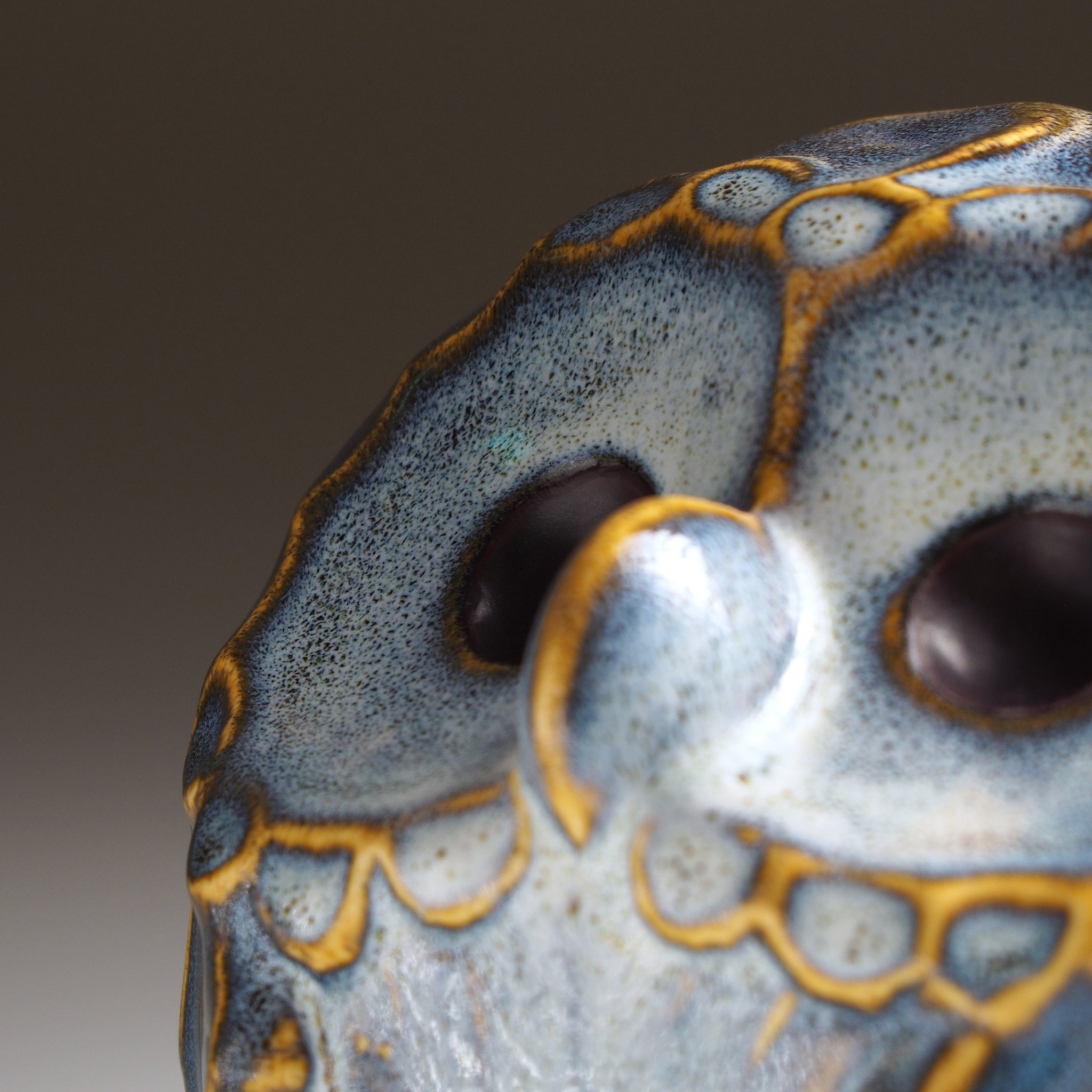 Face detail of the Fukumori medium ceramic owl figurine by Kazuhiro Kojima, ivory and amber Nanasai Tenmoku glaze, handcrafted in Japan.