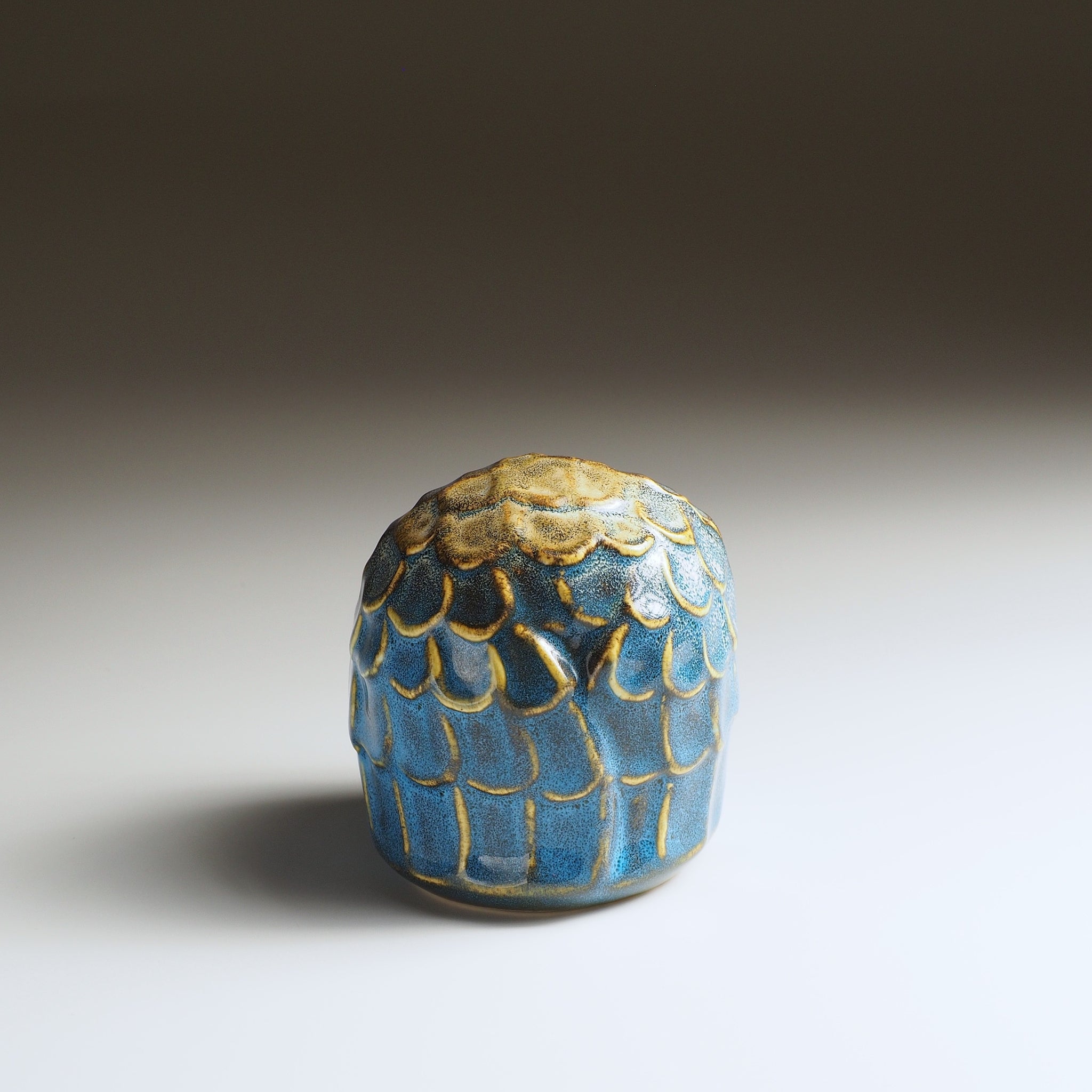 Back view of the small Fukumori owl-shaped ceramic ornament with blue glaze and gold feather details
