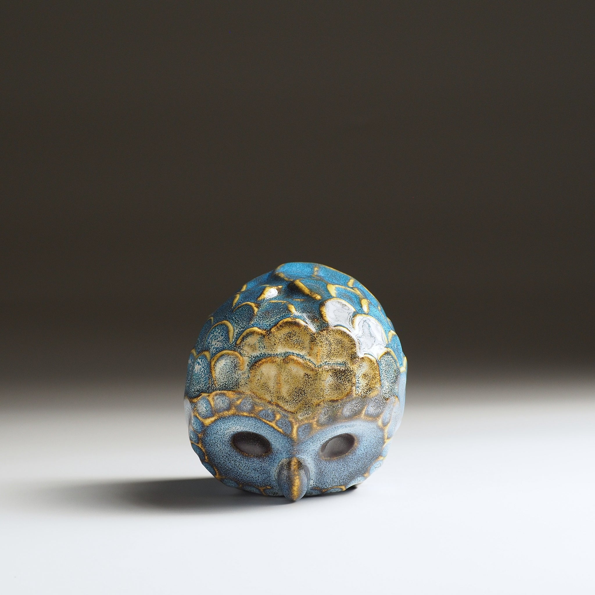 Top view of the small Fukumori owl-shaped ceramic ornament showing blue glaze and gold-outlined feather details