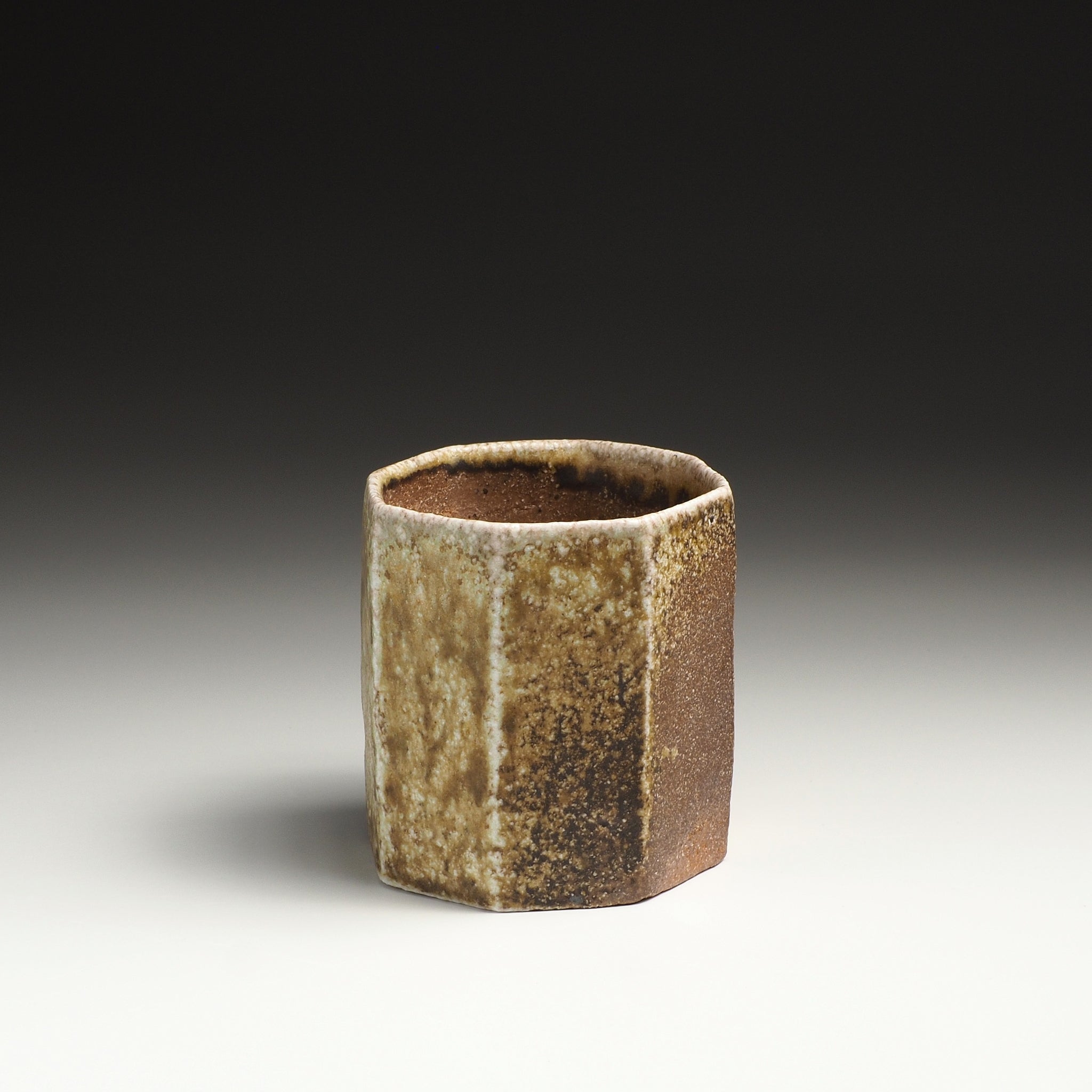 Single Hachiryō Shigaraki cup with a faceted form and mottled beige, brown, and gray surface.