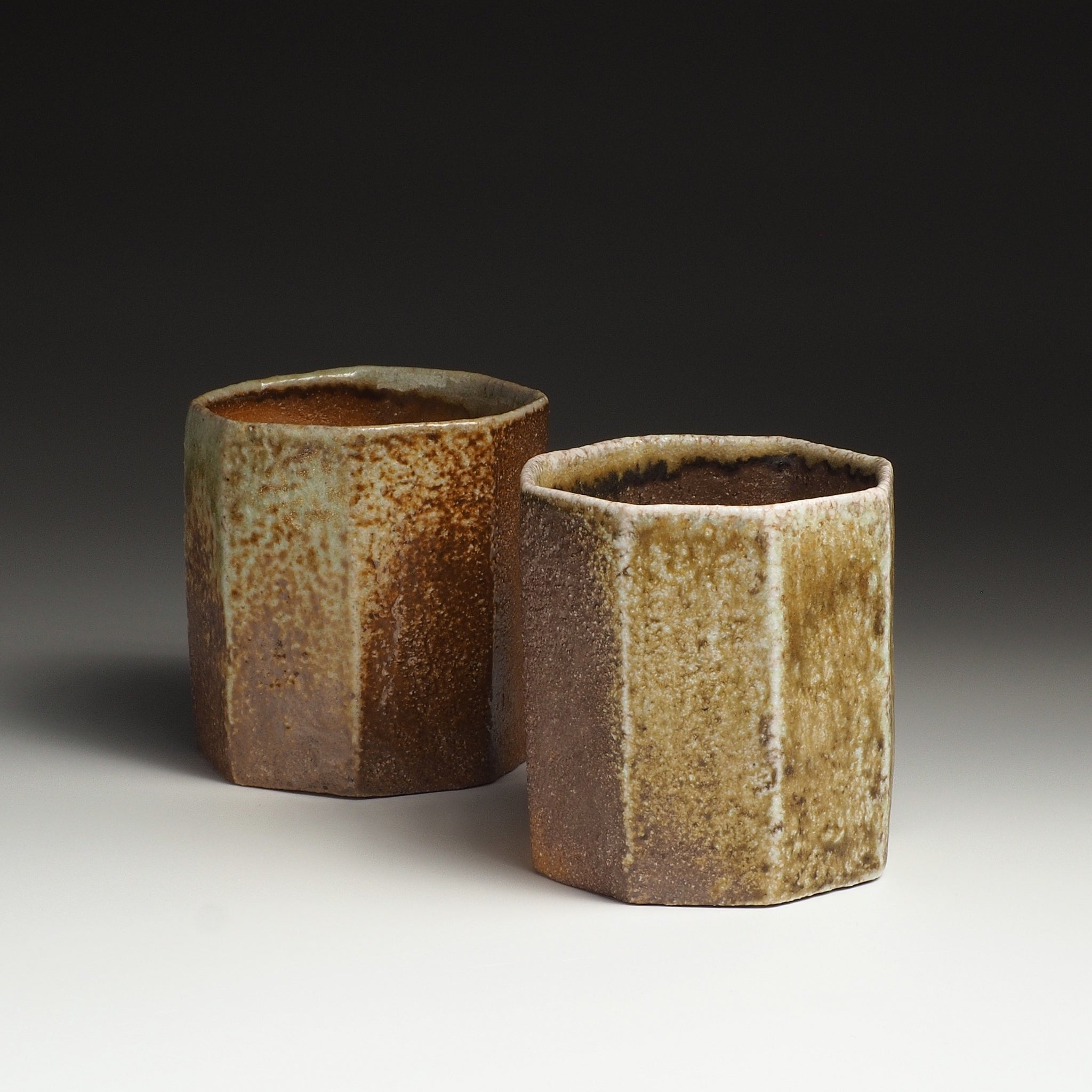 Two Hachiryō handmade Shigaraki cups with faceted octagonal forms and contrasting earthy surfaces.