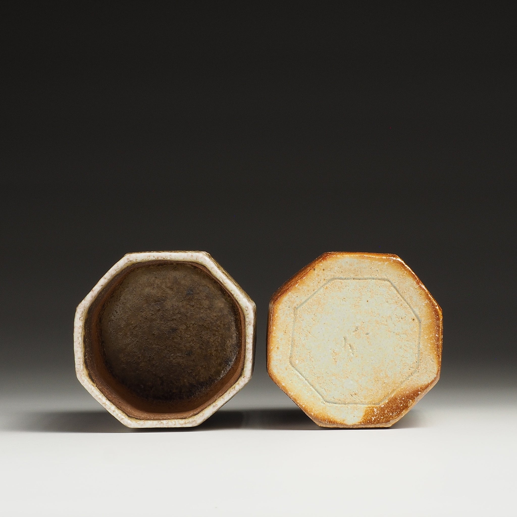 Hachiryō Shigaraki cup set showing the dark interior of one octagonal cup and the pale base of the other.