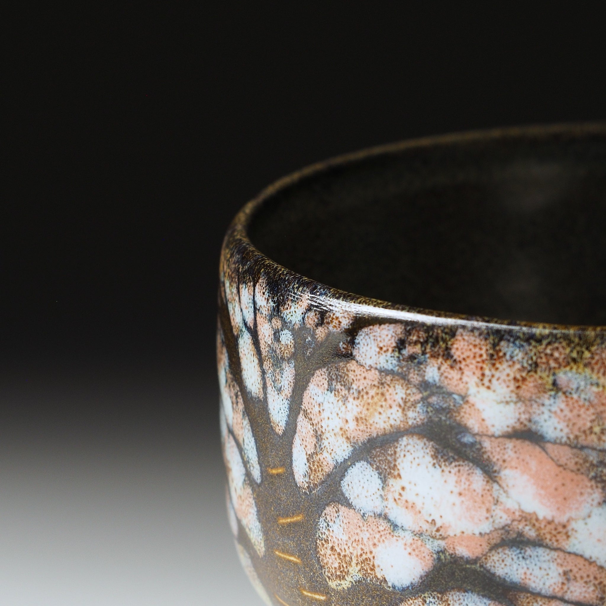 Sakura tree branches in kiln-fired Nanasai Tenmoku glaze, close-up detail, Hanagumo matcha bowl by Taro Kojima