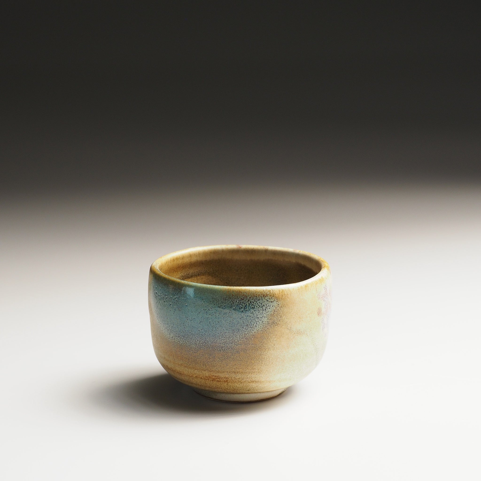 Japanese sake cup with sakura decorations on a gradient background