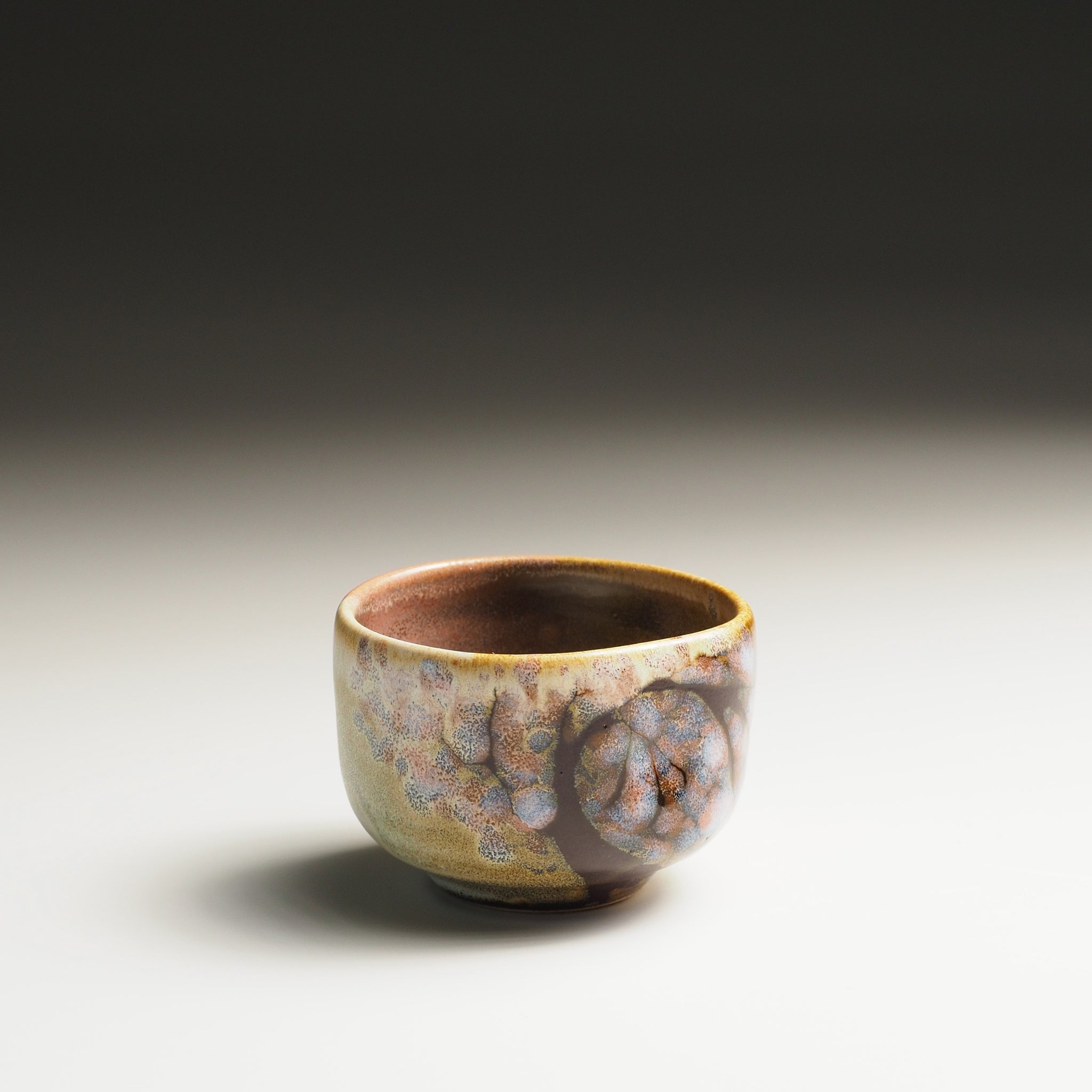 Japanese sake cup with a textured surface and sakura decorations and pink shades