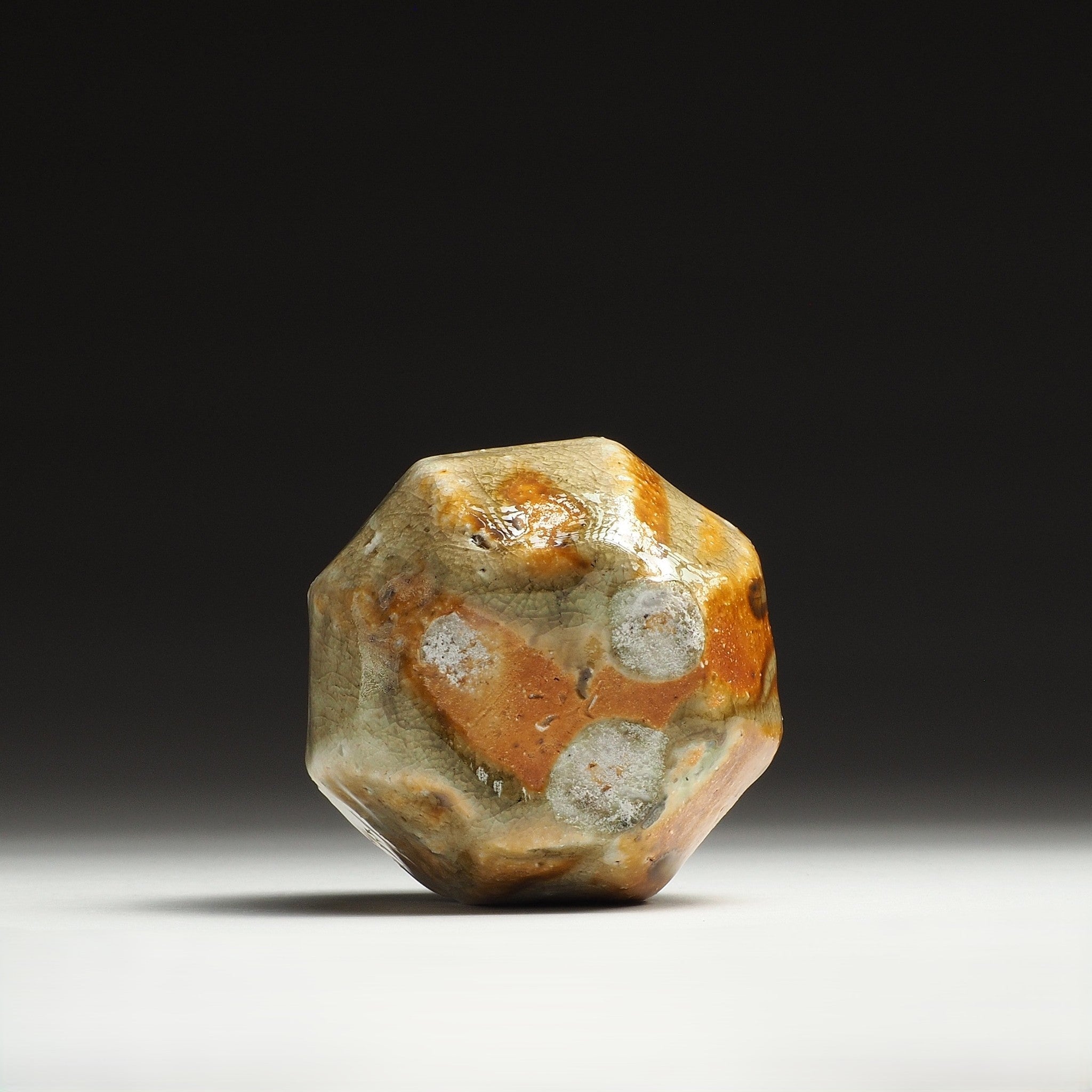 Bottom view of the Kokeishi Shigaraki flower vase showing the faceted base and mottled beige, amber, and brown firing tones.