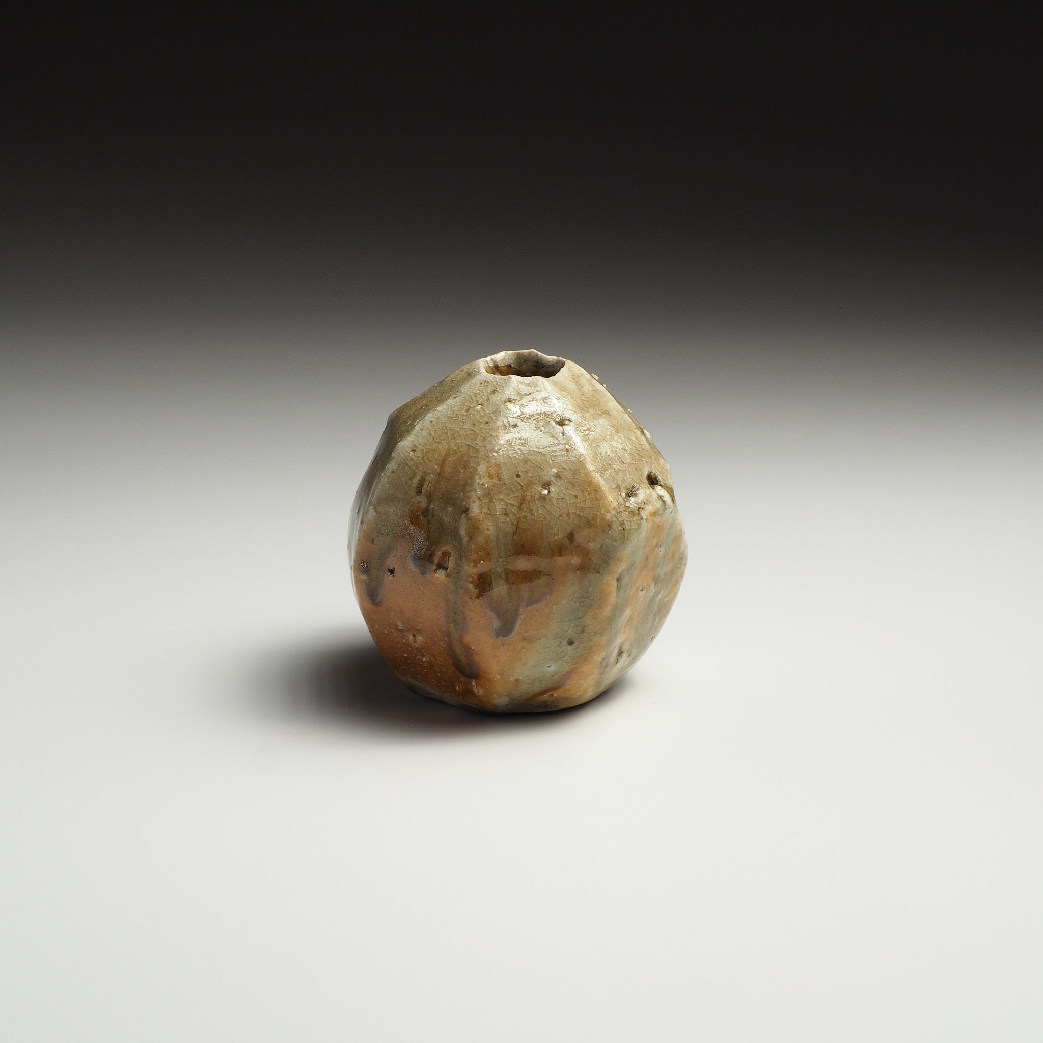 Kokeishi handmade Shigaraki flower vase with a rounded faceted form, small opening, and mottled beige, amber, and brown natural surface.