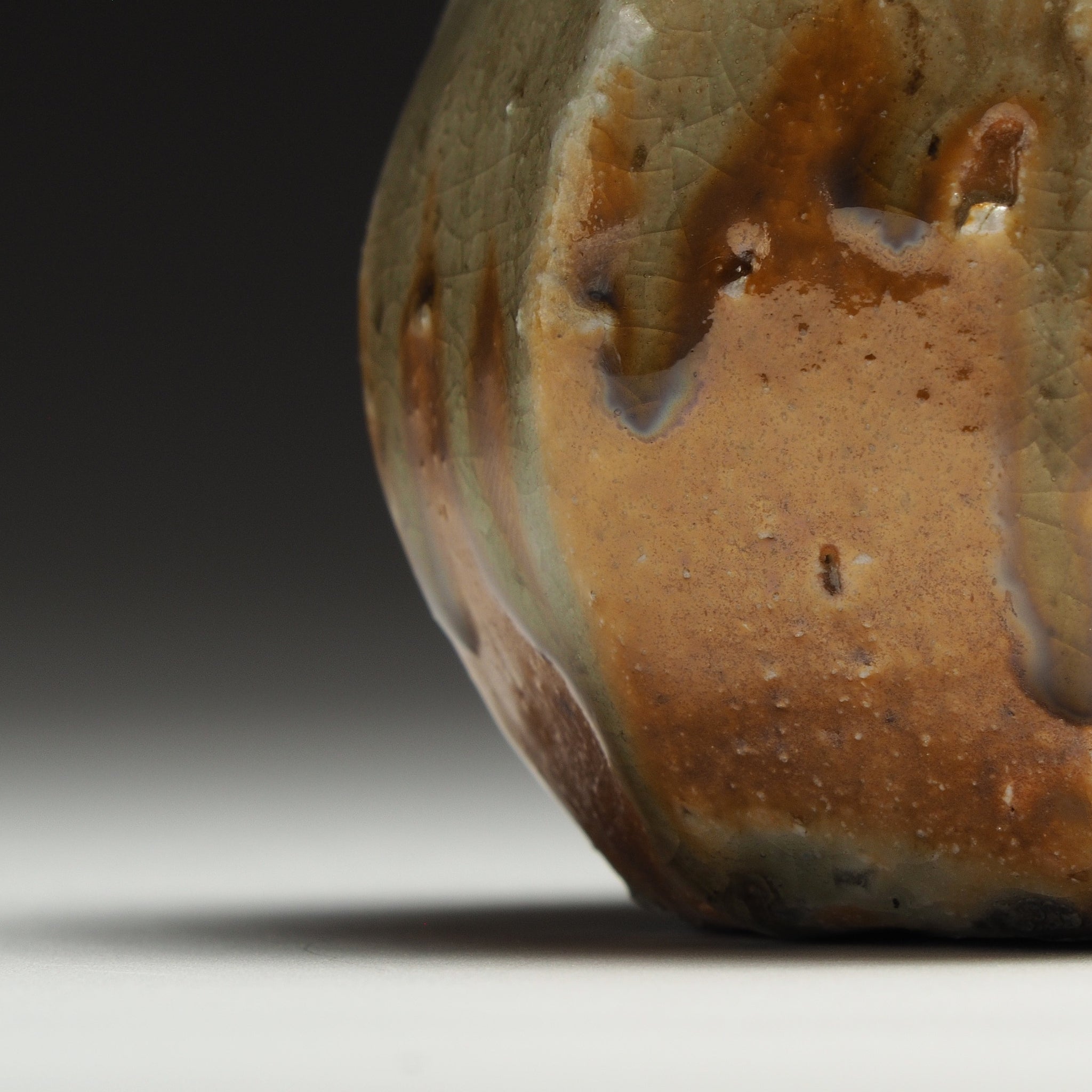 Close-up of the Kokeishi Shigaraki flower vase showing glossy amber glaze and vertical firing marks near the base.