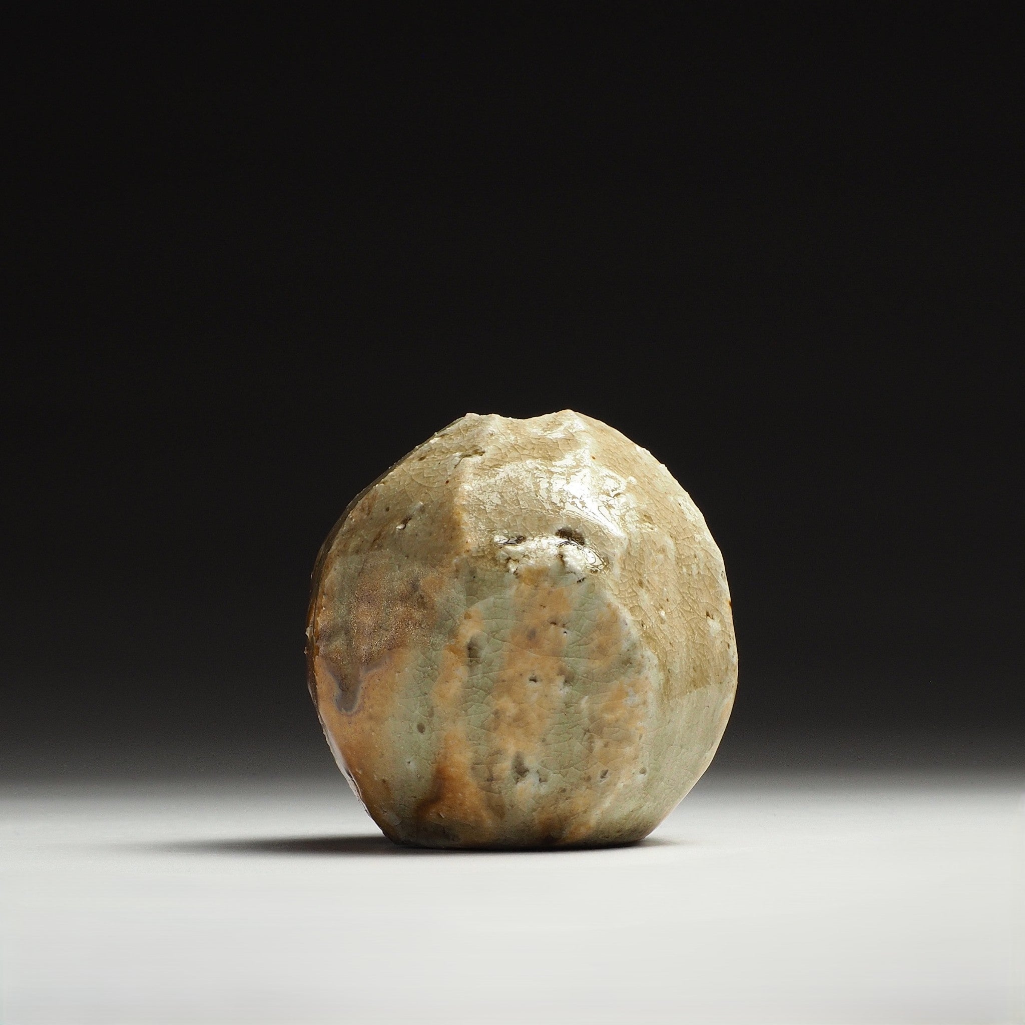 Front view of the Kokeishi Shigaraki flower vase showing its rounded form and vertical beige and amber surface markings.