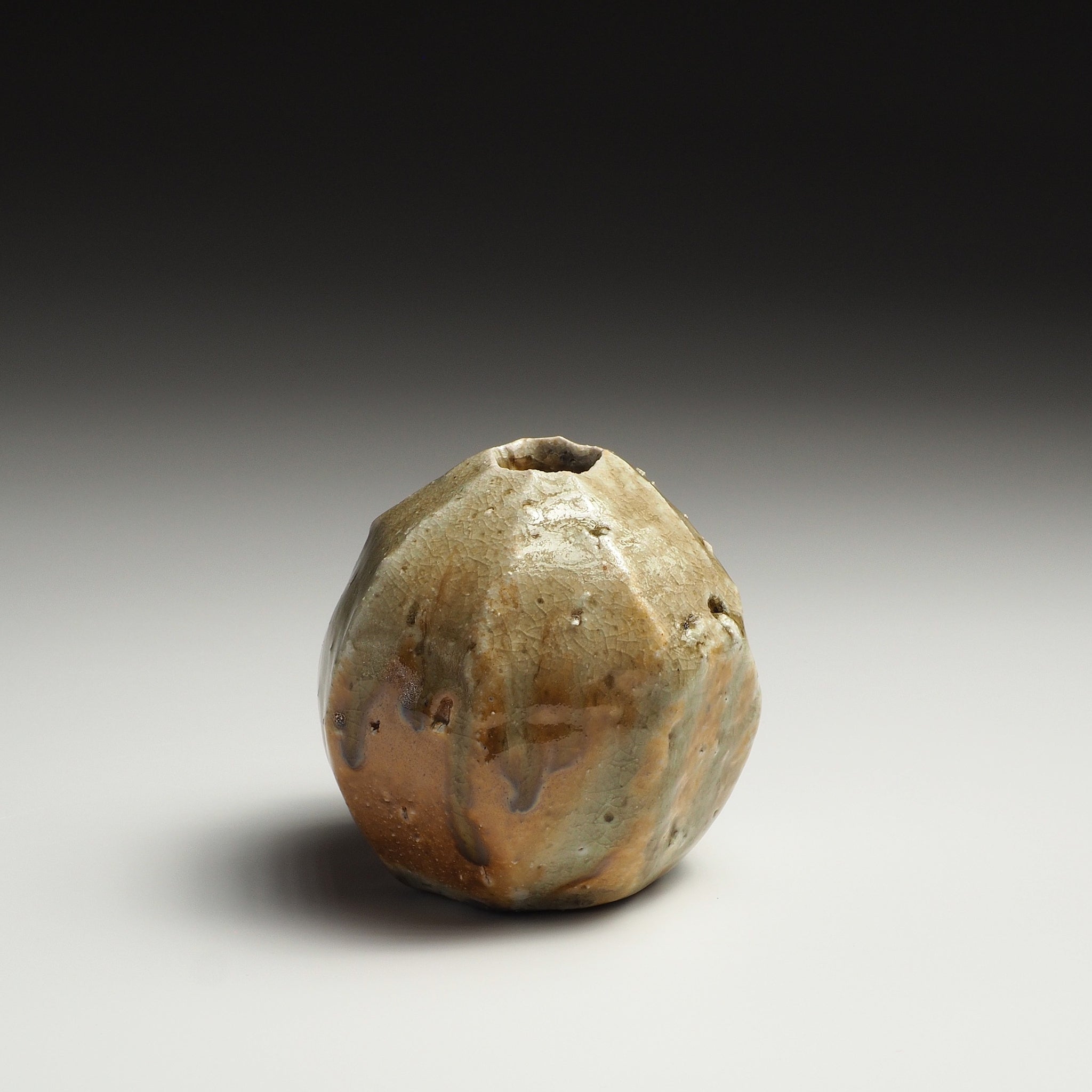 Angled view of the Kokeishi handmade Shigaraki flower vase showing its irregular faceted form and small opening.