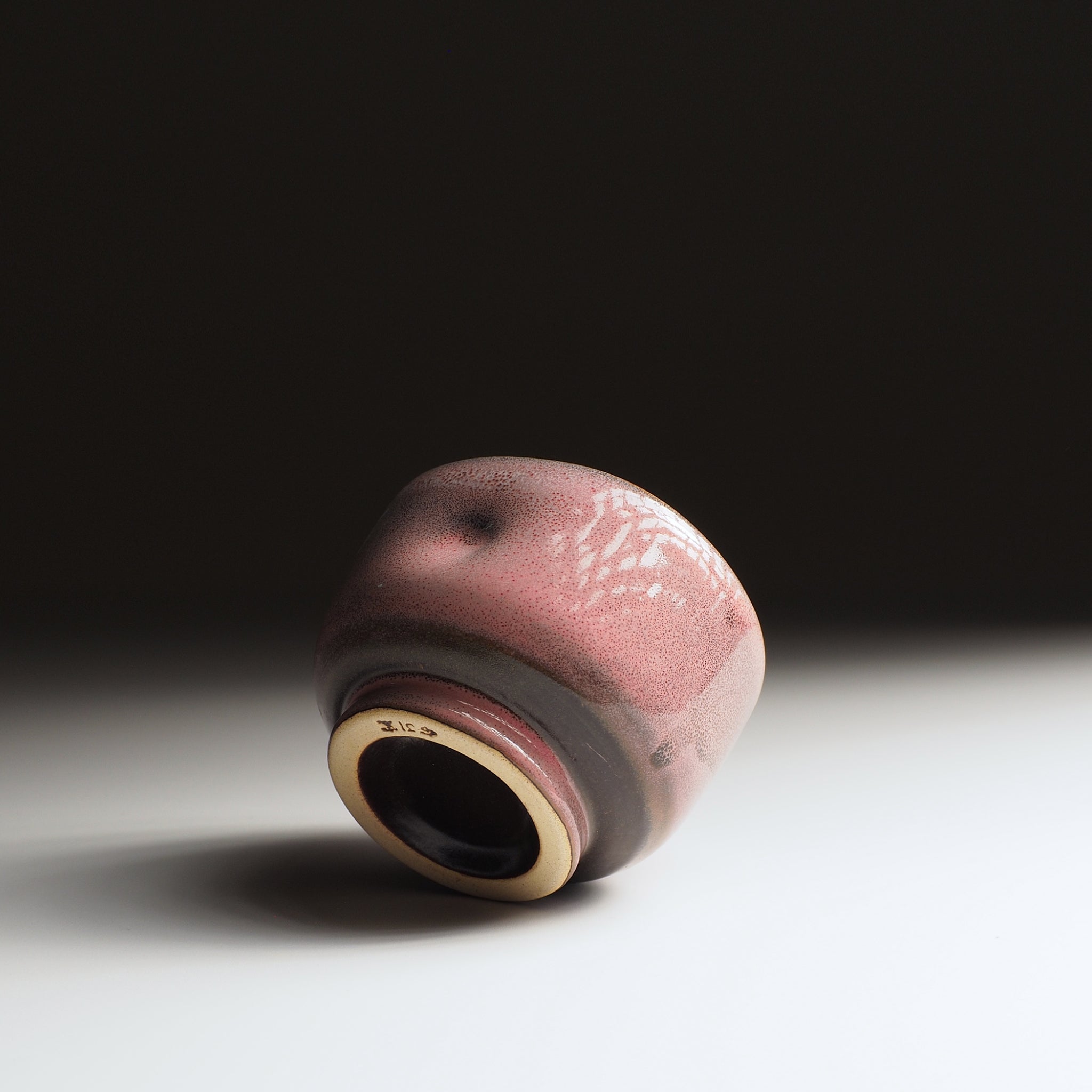 Japanese pink ceramic yunomi teacup on a gradient background