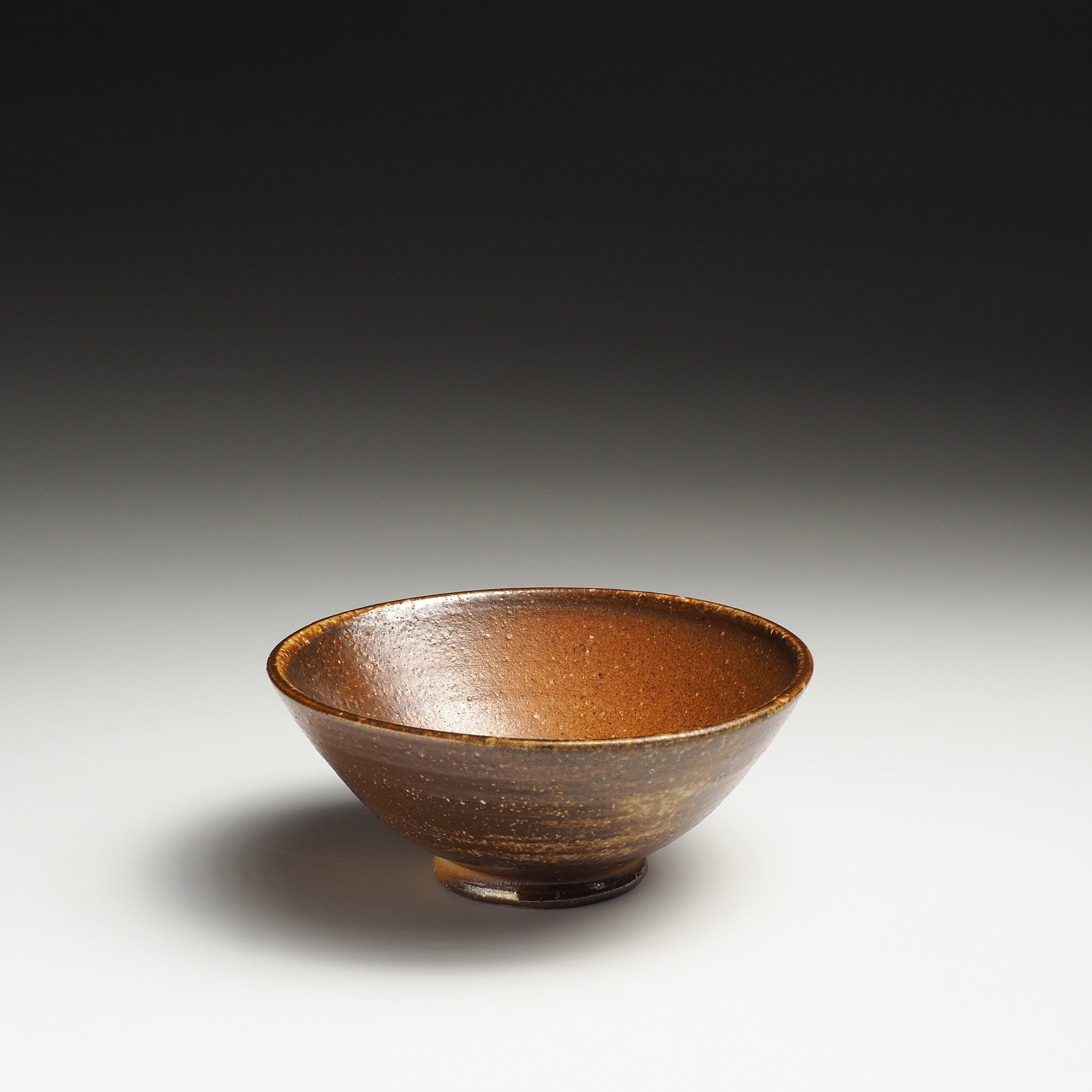 Single Mizuho handmade Shigaraki rice bowl showing its open form and warm brown interior glaze.