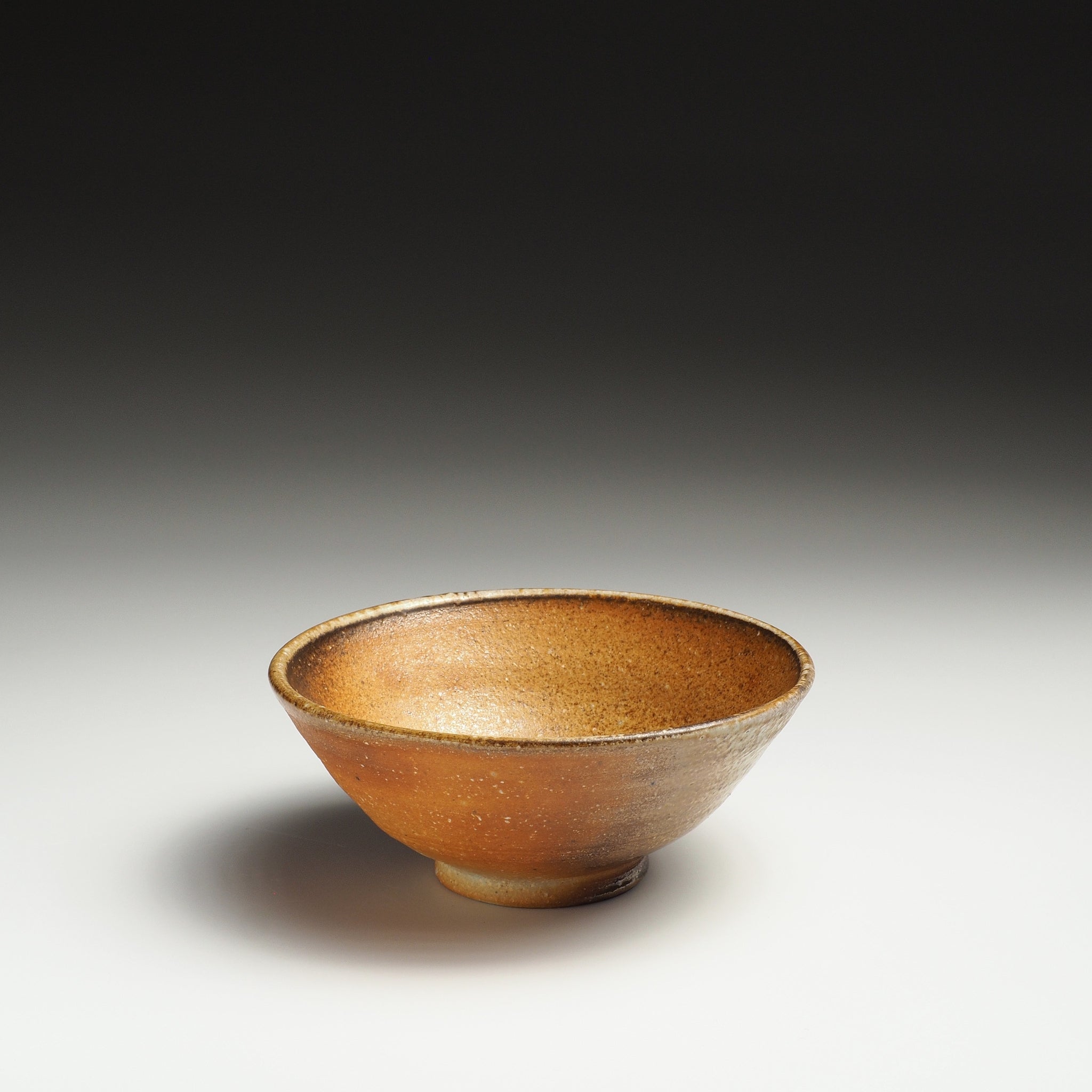 Single Mizuho handmade Shigaraki rice bowl with warm amber-brown tones and a gently rounded form.