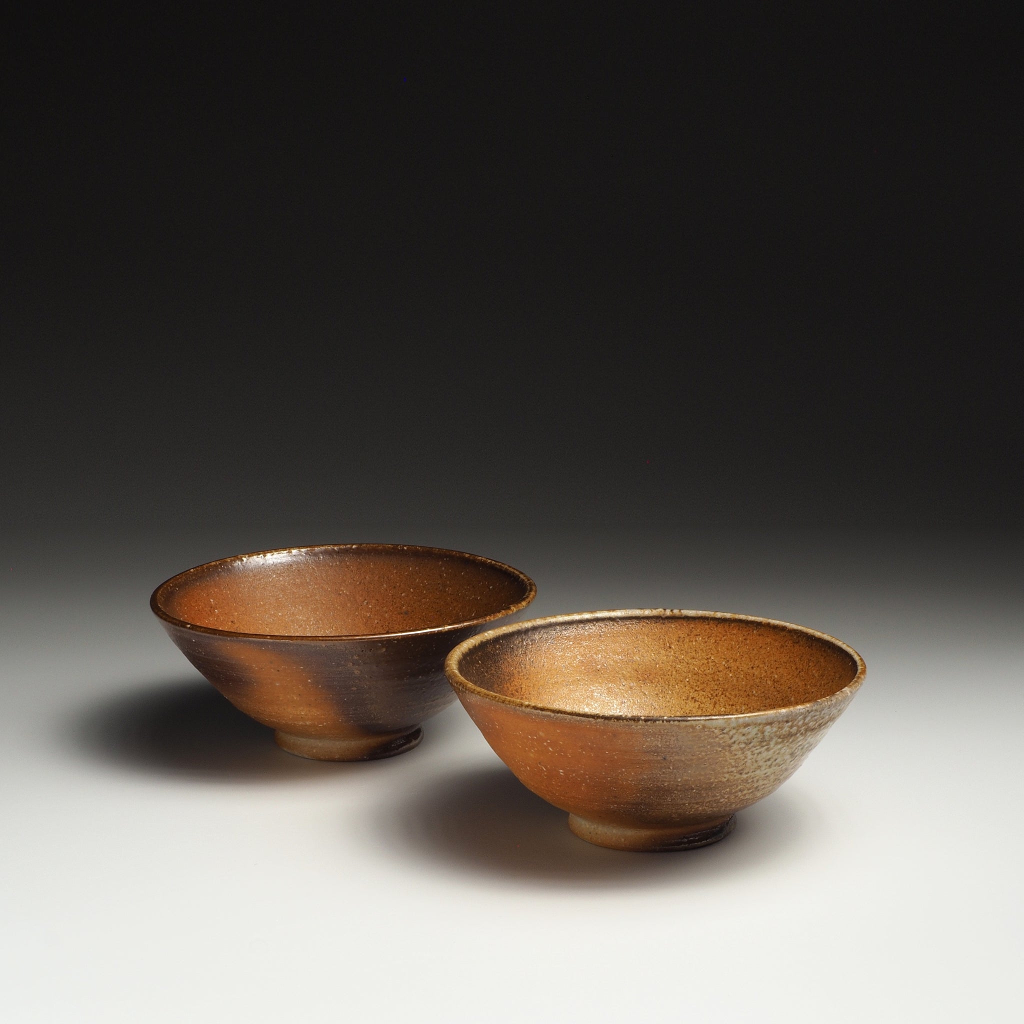 Two Mizuho handmade Shigaraki rice bowls with warm brown and beige natural ash-fired surfaces.