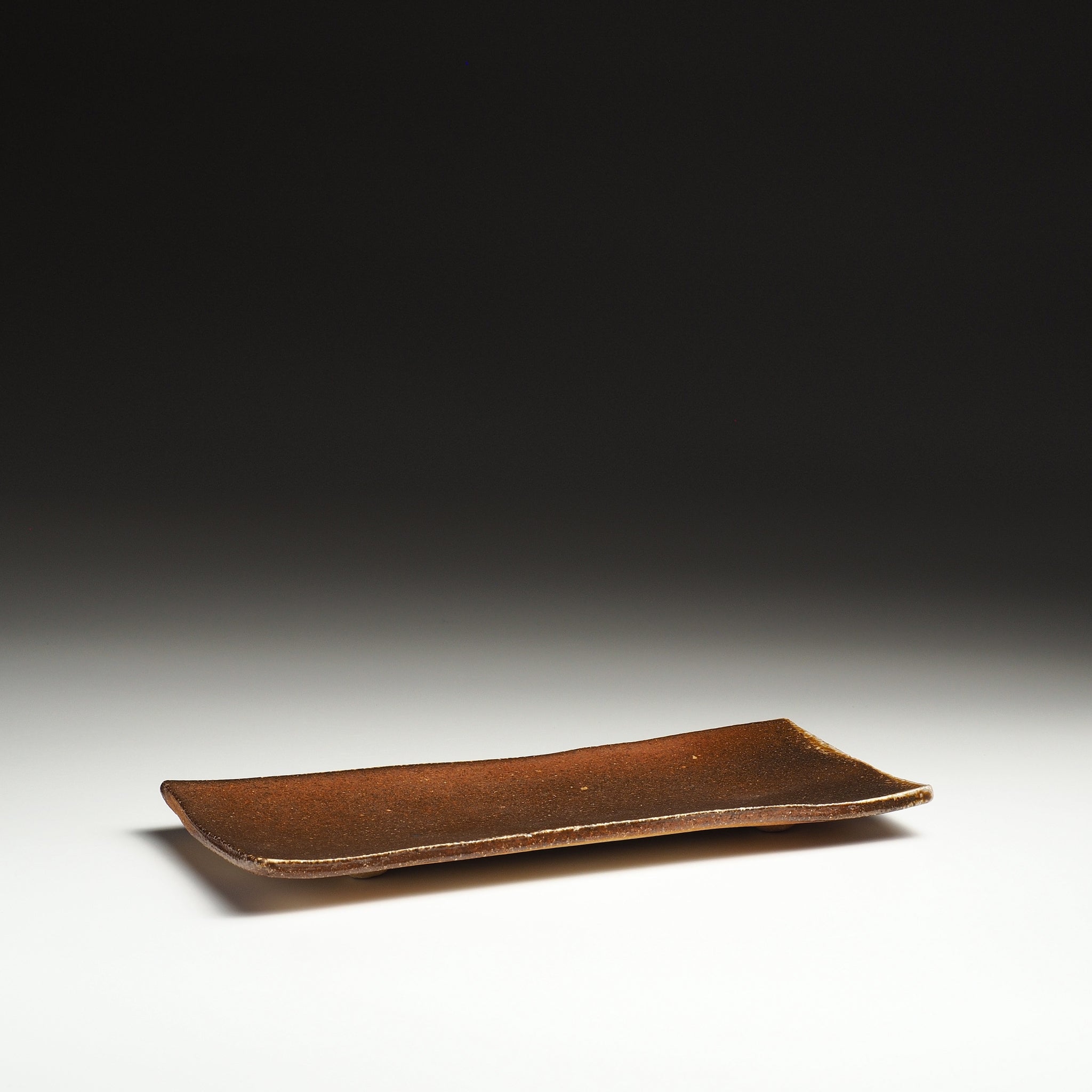 Nagafune handmade Shigaraki rectangular serving plate with a long gently curved form and warm brown surface.