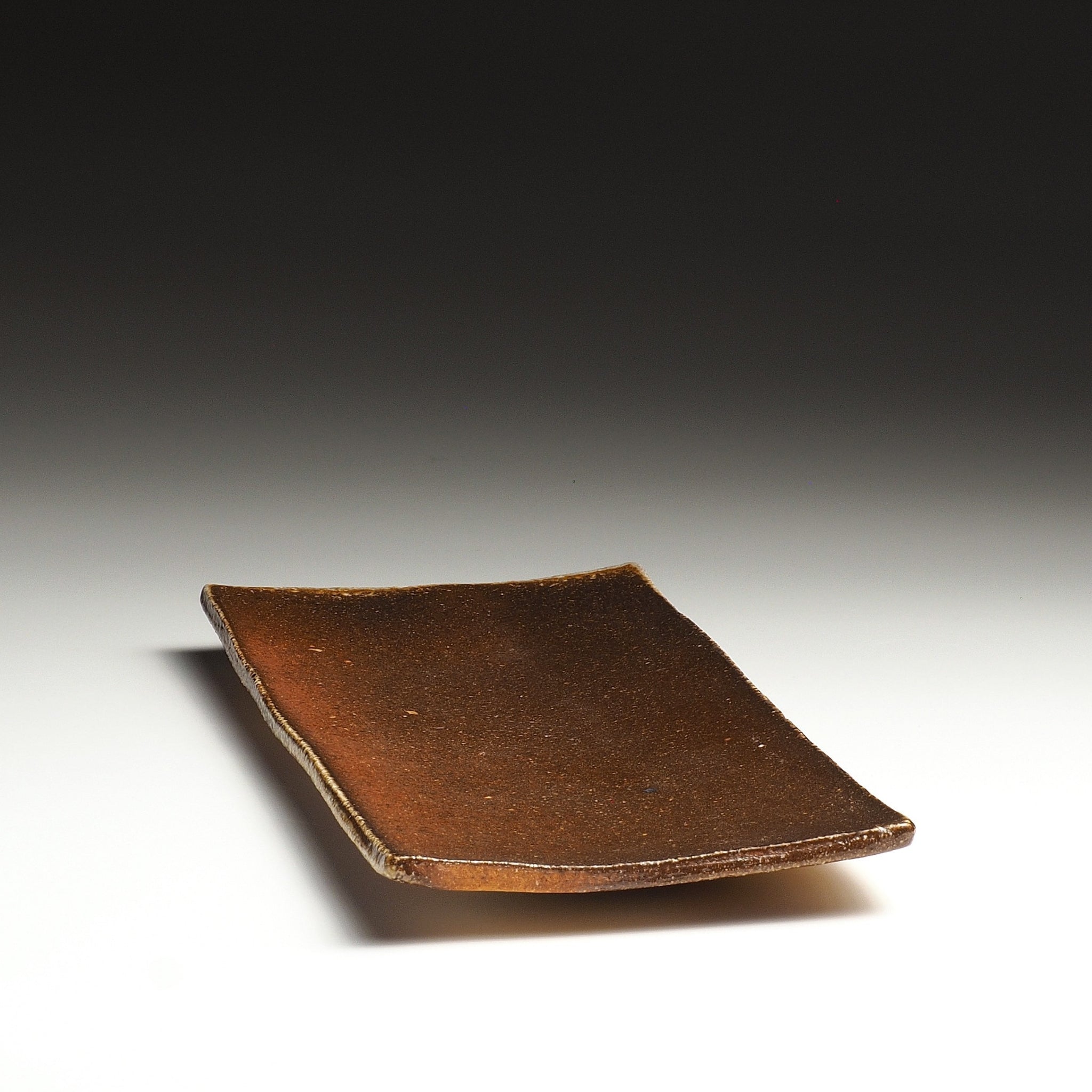Angled view of the Nagafune handmade Shigaraki serving plate showing its rectangular shape and softly raised corners.