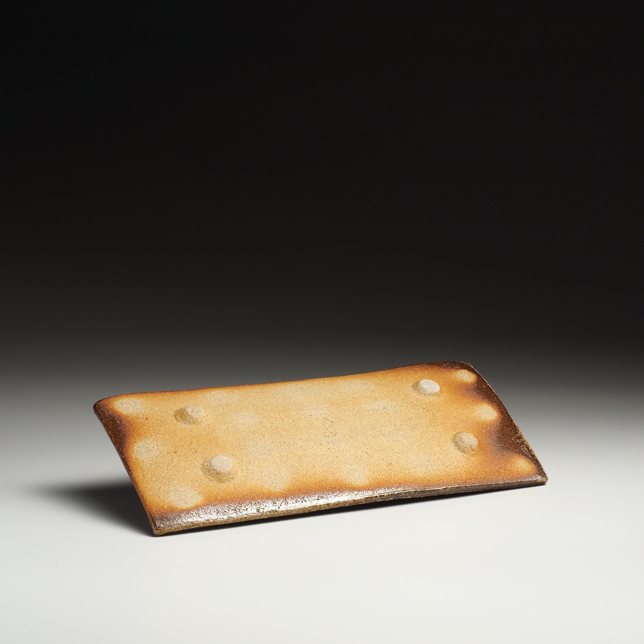 Underside view of the Nagafune Shigaraki rectangular serving plate showing its pale base and four small foot supports.