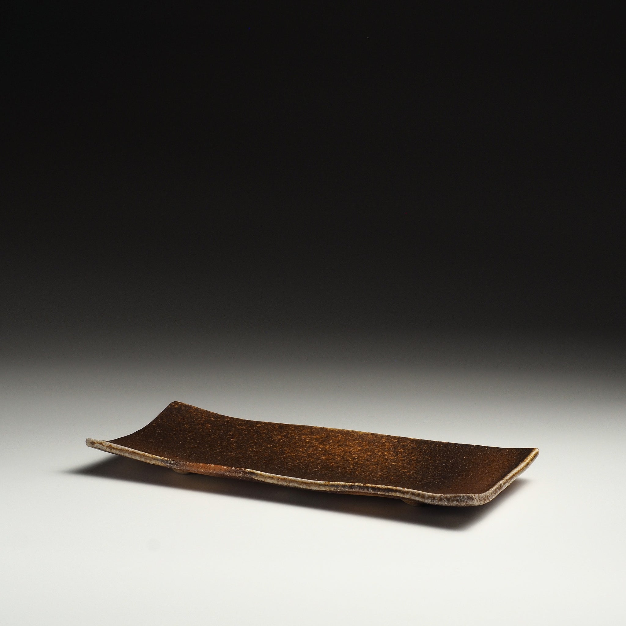 Angled view of the Nagafune handmade Shigaraki serving plate showing its long rectangular form and softly lifted corners.