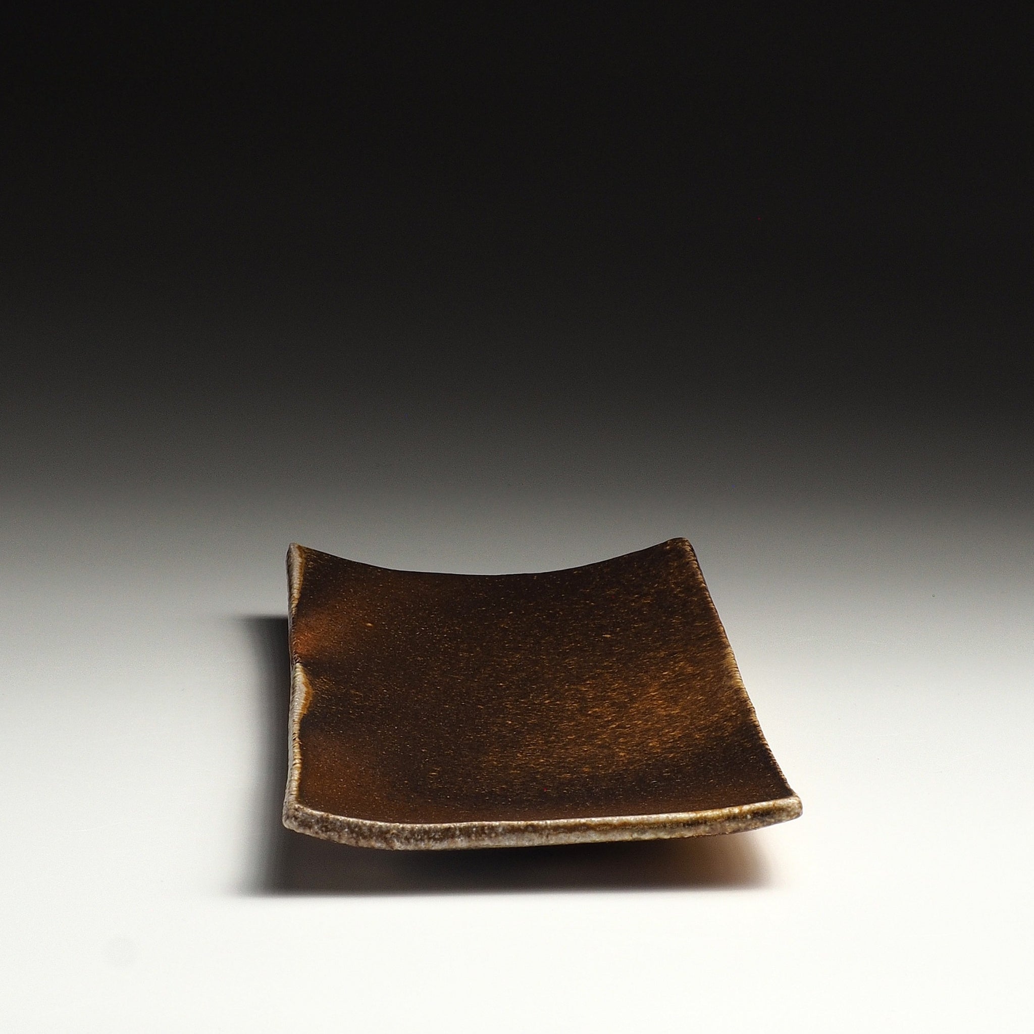 Angled top view of the Nagafune Shigaraki rectangular serving plate showing its warm brown surface and gently curved shape.