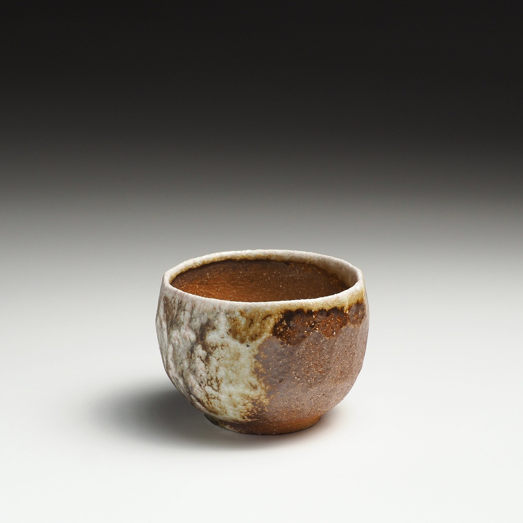 Single Ryoen handmade Shigaraki yunomi with a mottled beige and gray glazed surface.