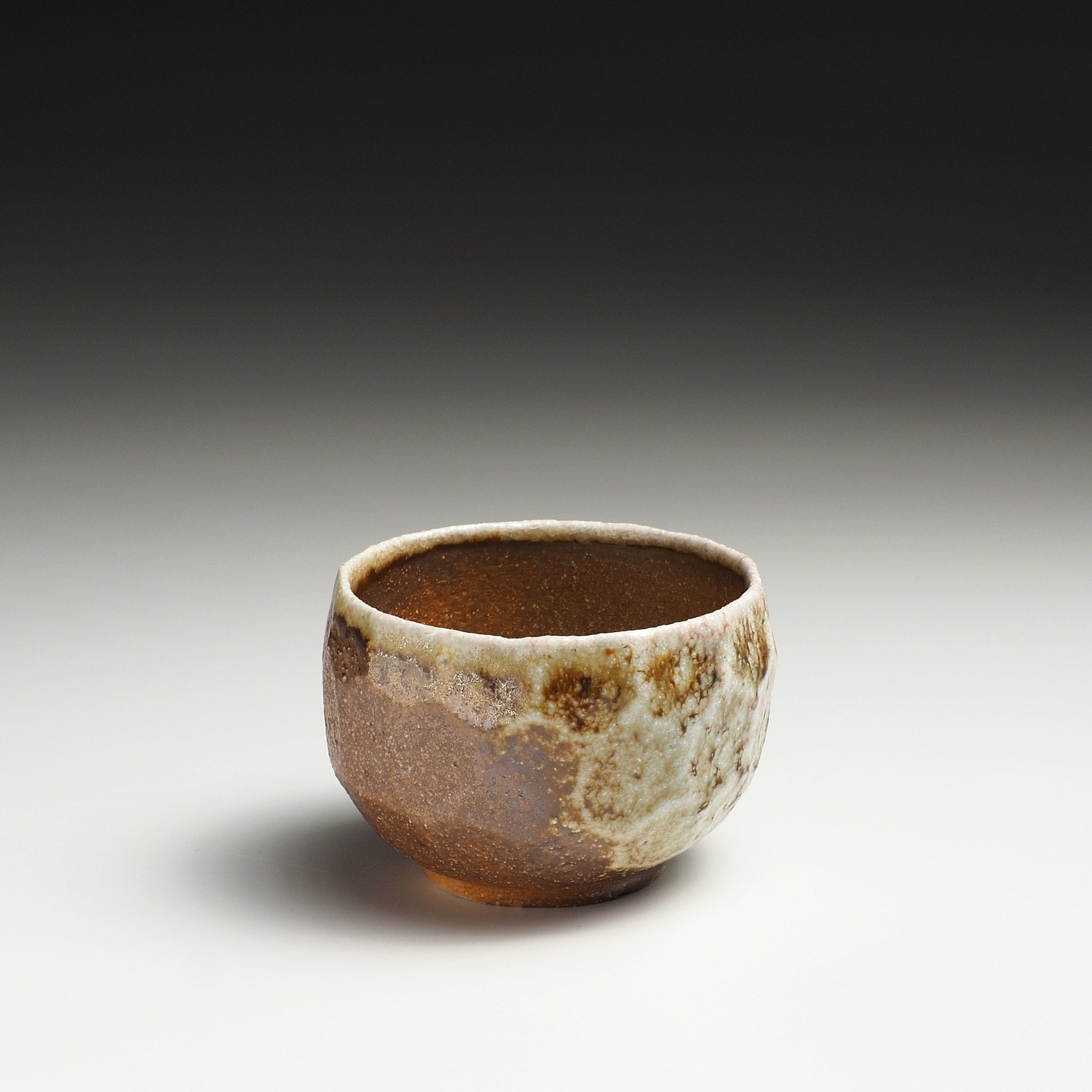 Single Ryoen Shigaraki yunomi showing its rounded form and mottled brown, beige, and gray surface.