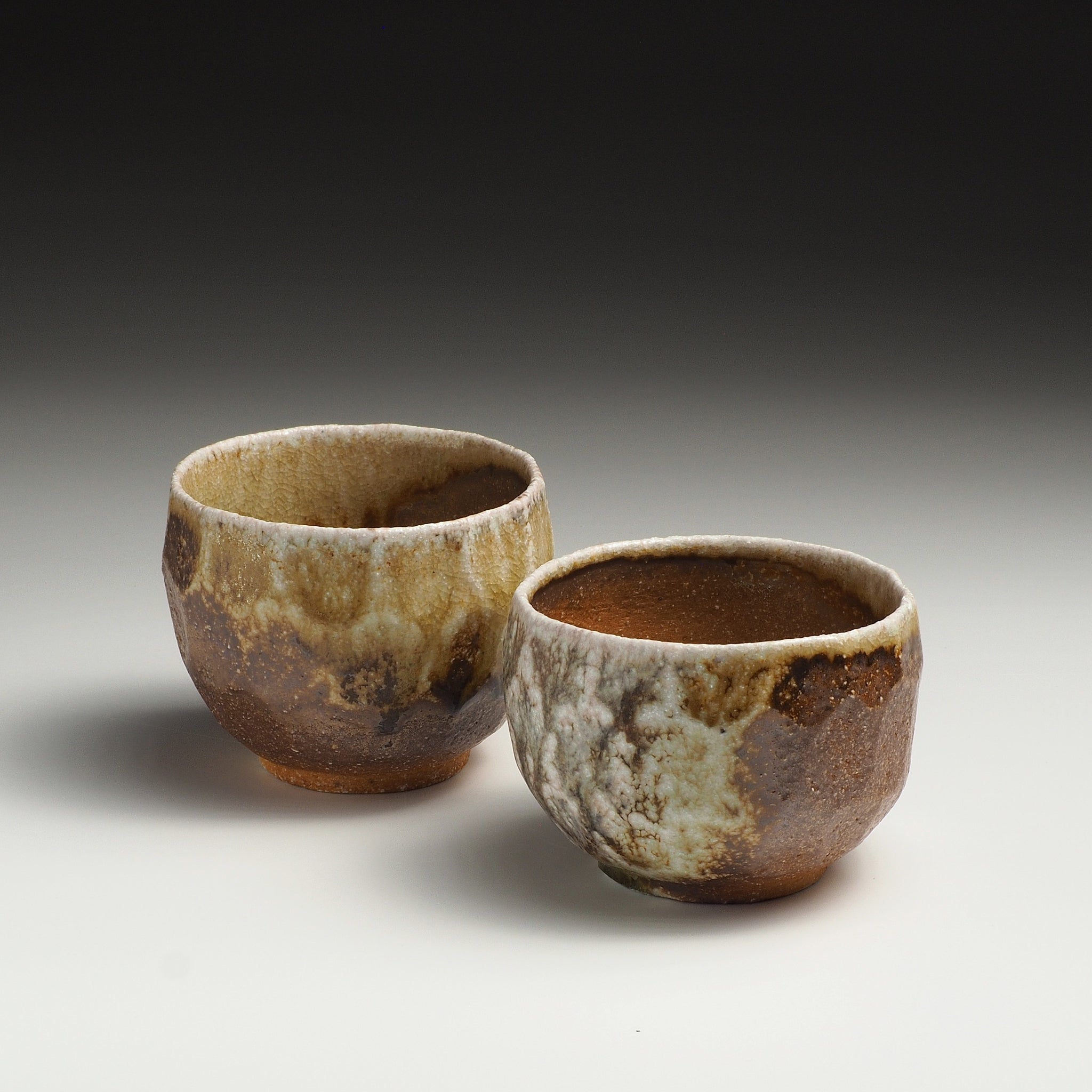 Two Ryoen handmade Shigaraki yunomi teacups showing their rounded forms and earthy mottled glaze.