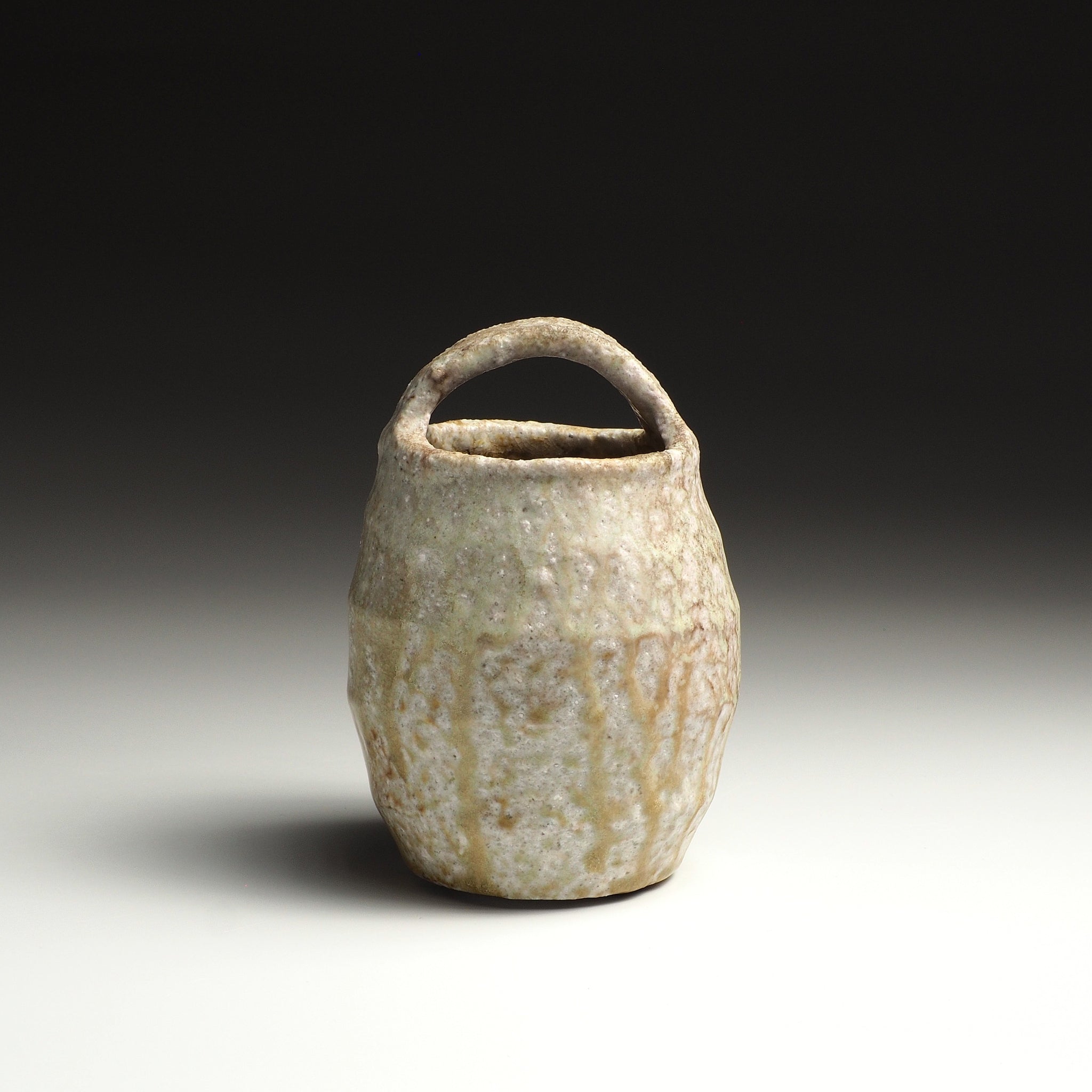 Front view of the Setsugan handmade Shigaraki flower vase with loop handle and vertically textured natural firing surface.