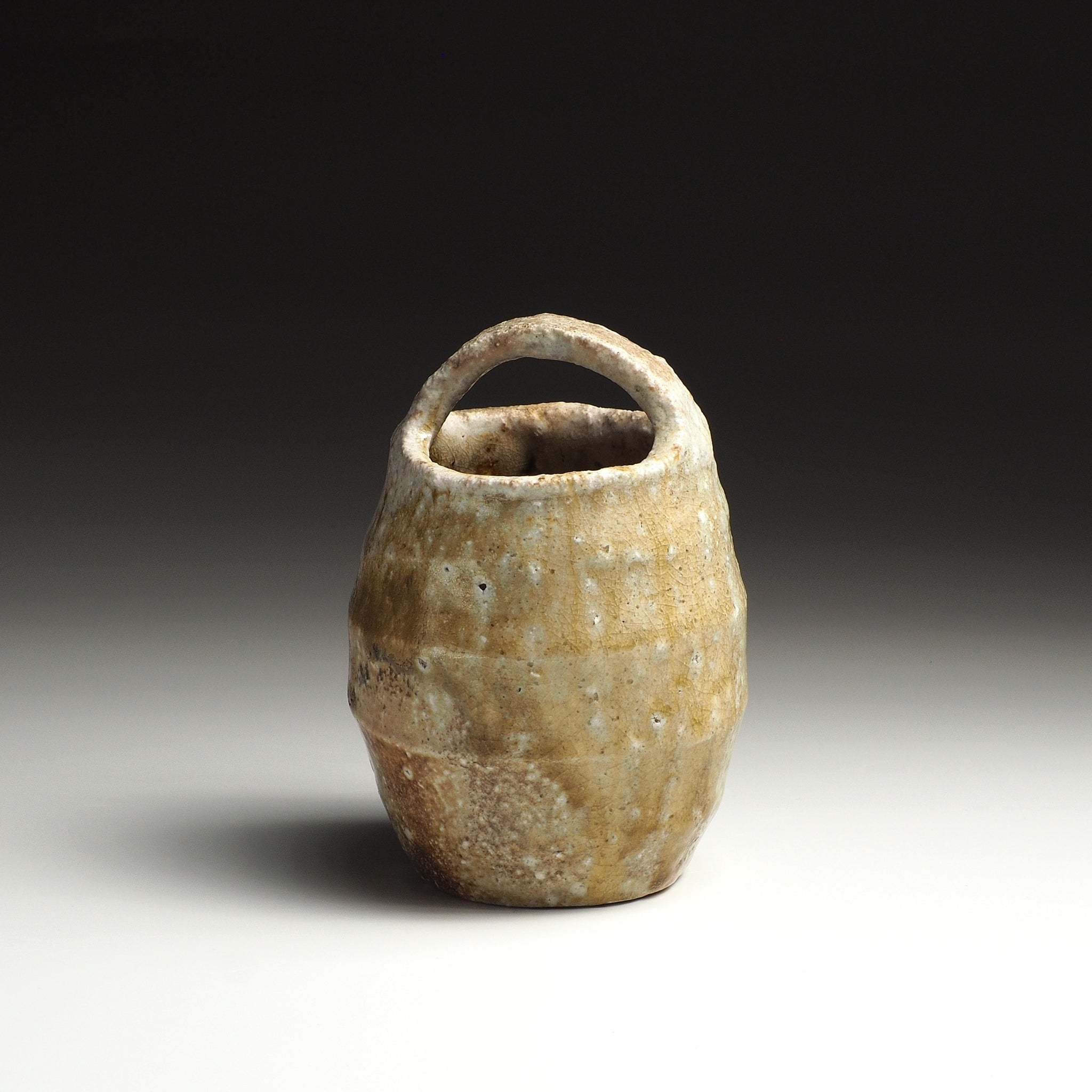 Angled view of the Setsugan Shigaraki flower vase showing warm beige and amber natural firing tones.