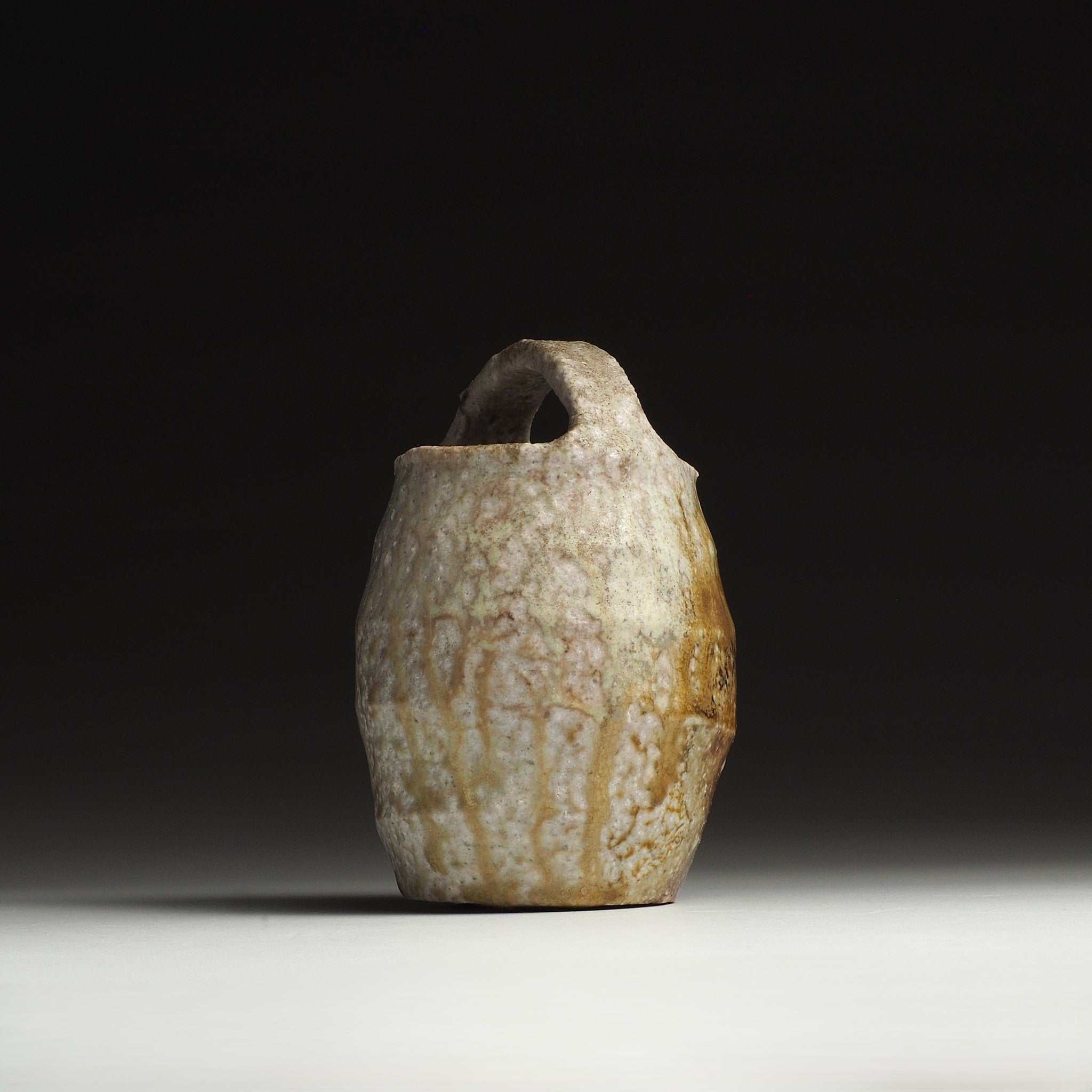 Front view of the Setsugan handmade Shigaraki flower vase showing its tall form, loop handle, and natural firing tones.