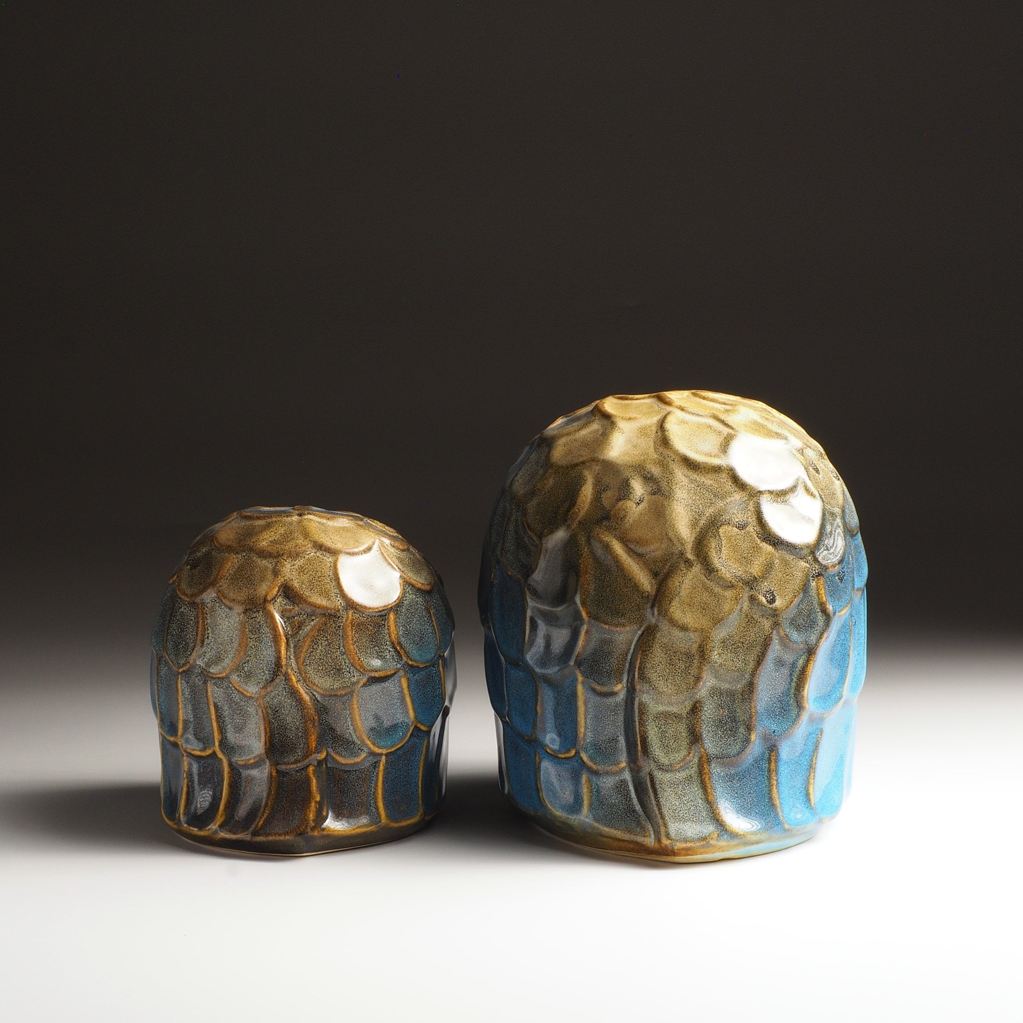 Back view of the Sofuku pair of owl-shaped ceramic ornaments in two sizes with layered blue and gold feather decoration